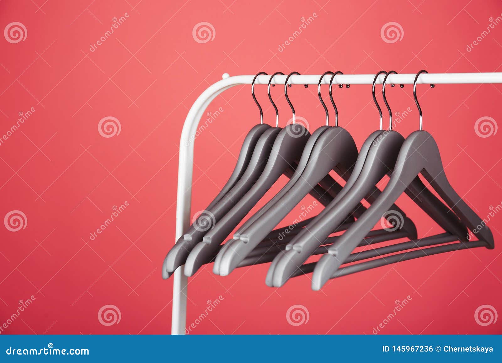 Empty Clothes Hangers On Metal Rack Against Color Background Stock ...