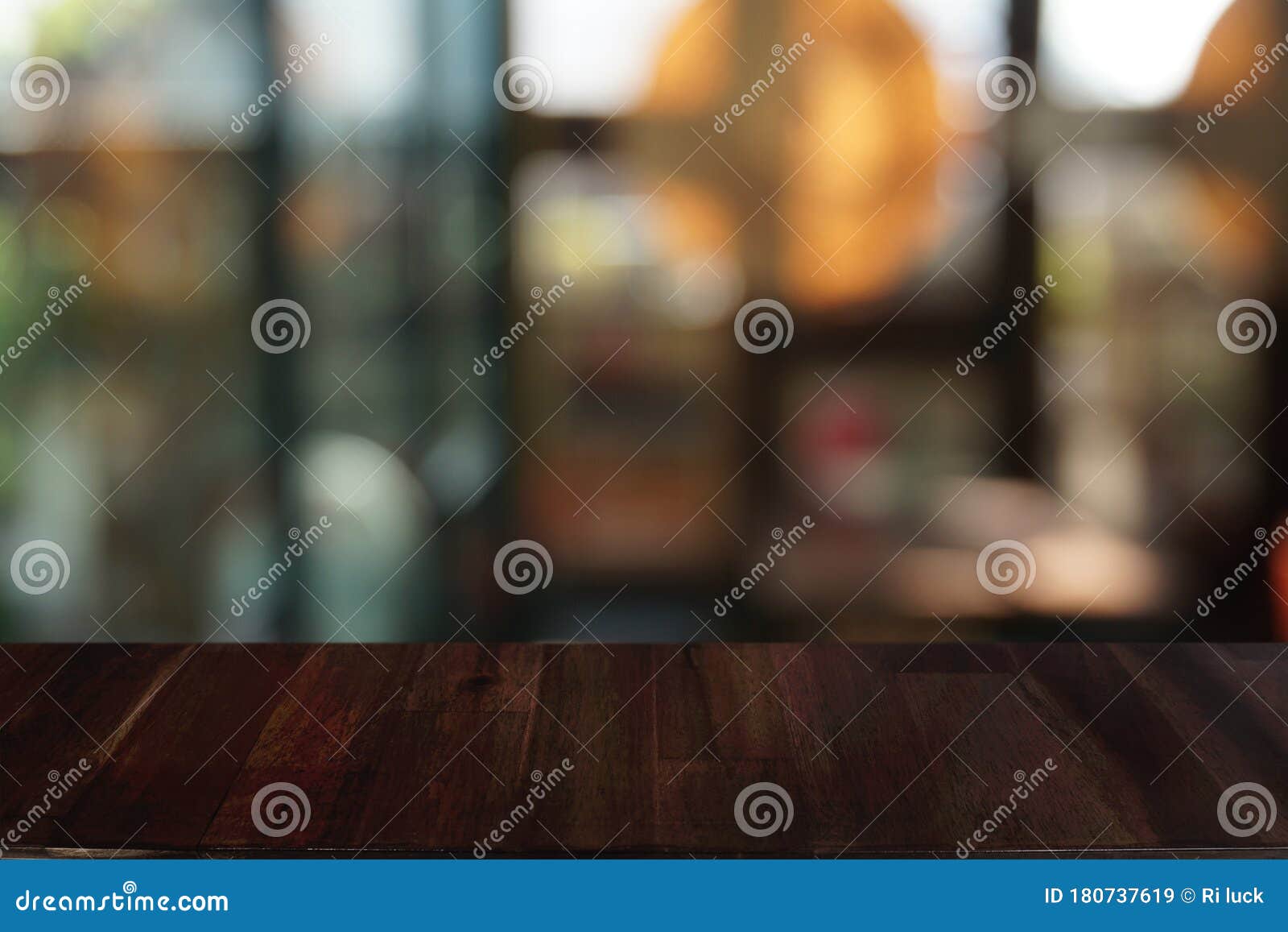 empty dark wooden table in front of abstract blurred bokeh background of restaurant.