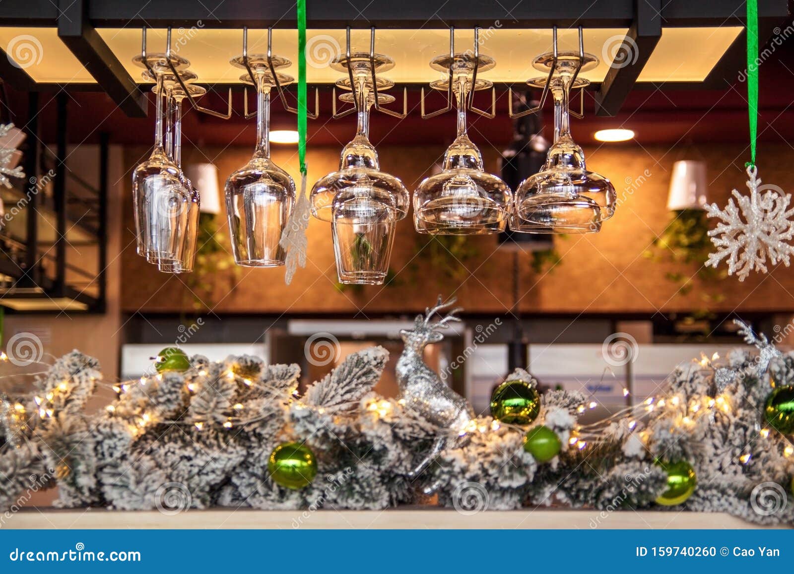 Empty Glasses of Wine Above a Bar Rack on the Christmas Decorations