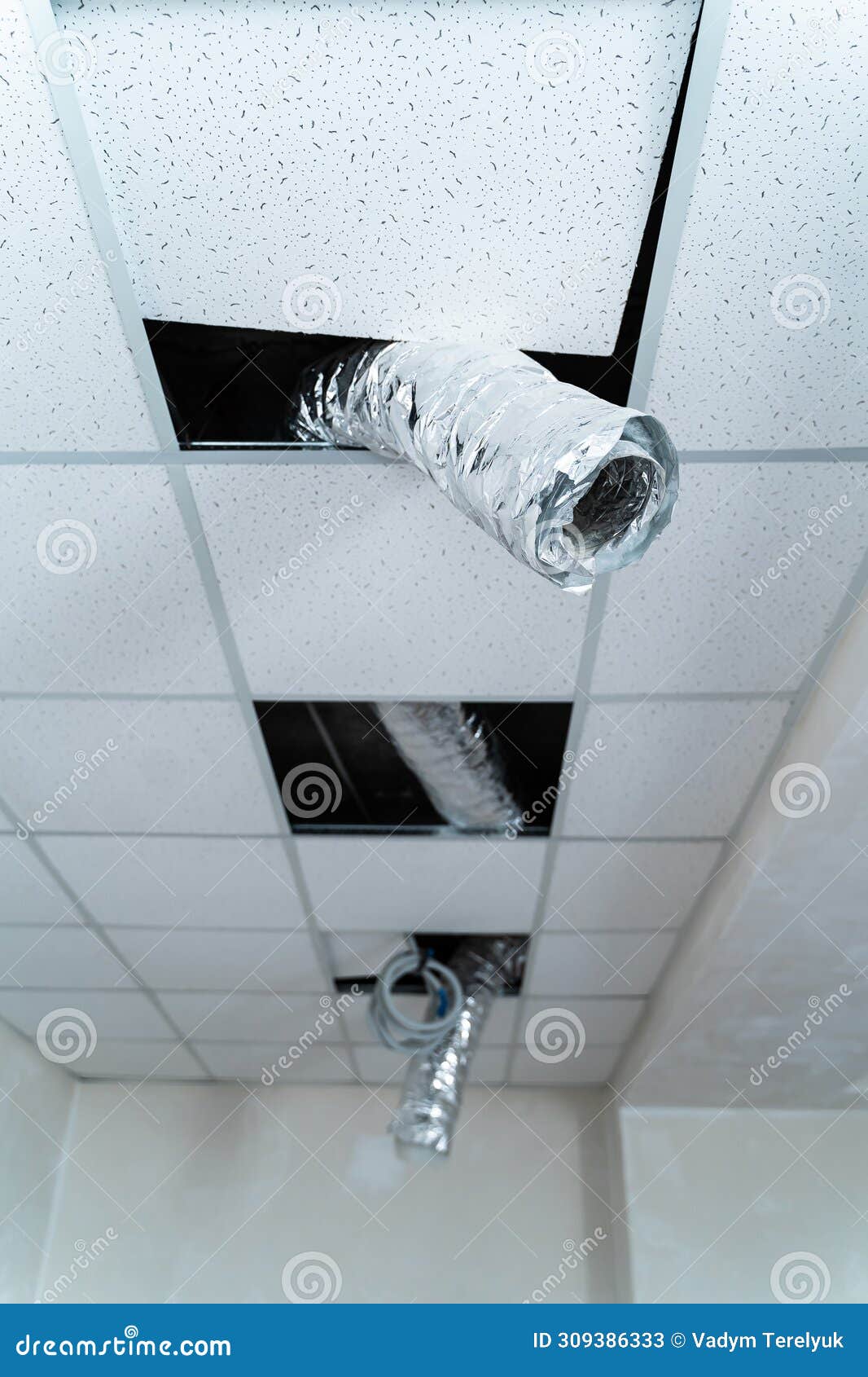 empty industrial facility with grey wall. internet cable hangs from the ceiling. air conditioning tube. closeup
