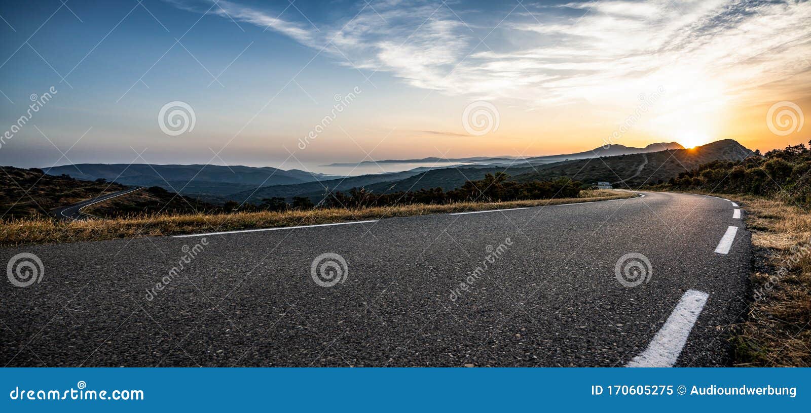 empty long mountain road to the horizon on a sunny summer day at bright sunset
