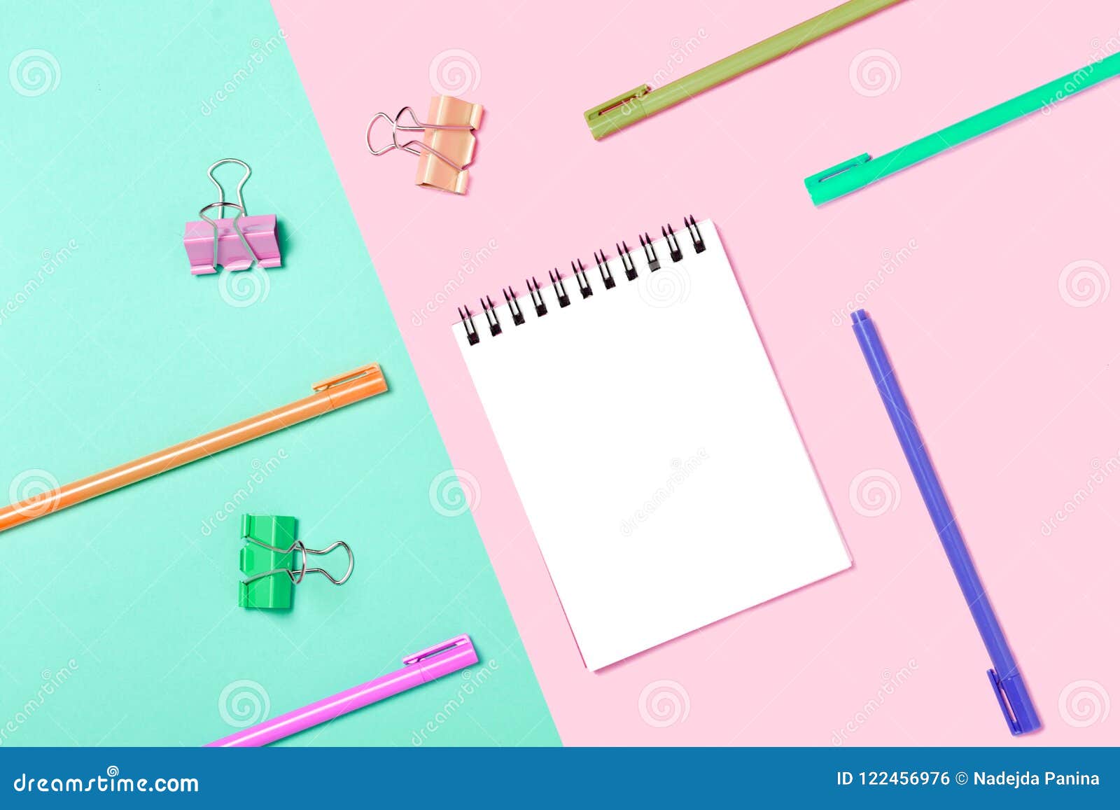 empty notebook or notepad on pink and blue background.