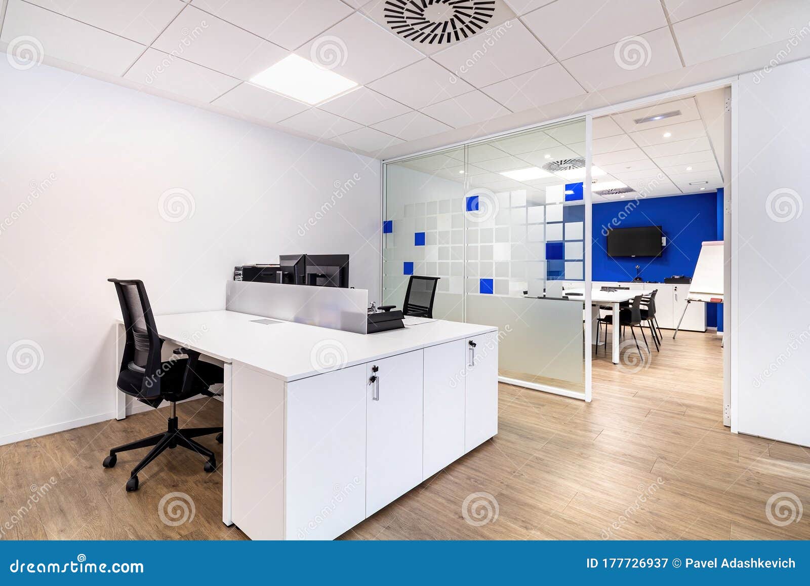 empty office with work spaces. modern office interior with blue and white walls. meeting room at the background.