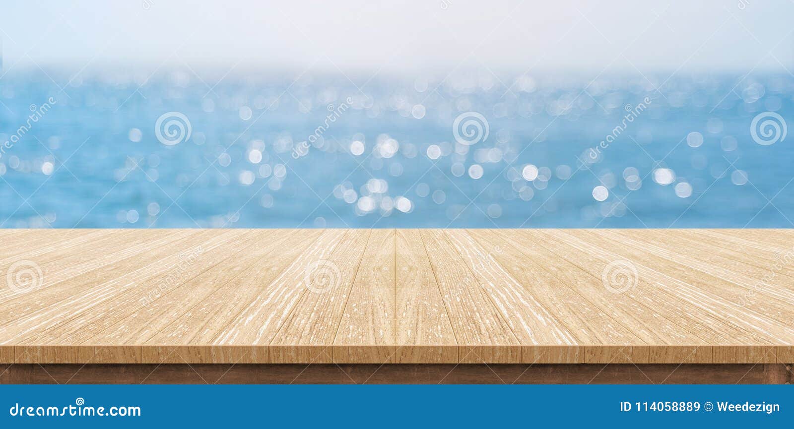 empty plank wood table top with blur blue sky and sea boekh back