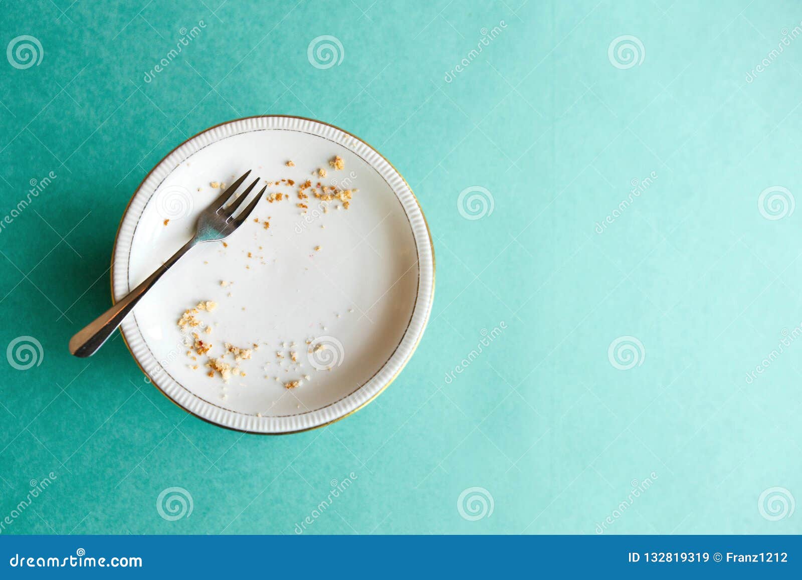 empty plate with crumbs after eating on a green background. the concept of the end of the holiday or celebration. nearby