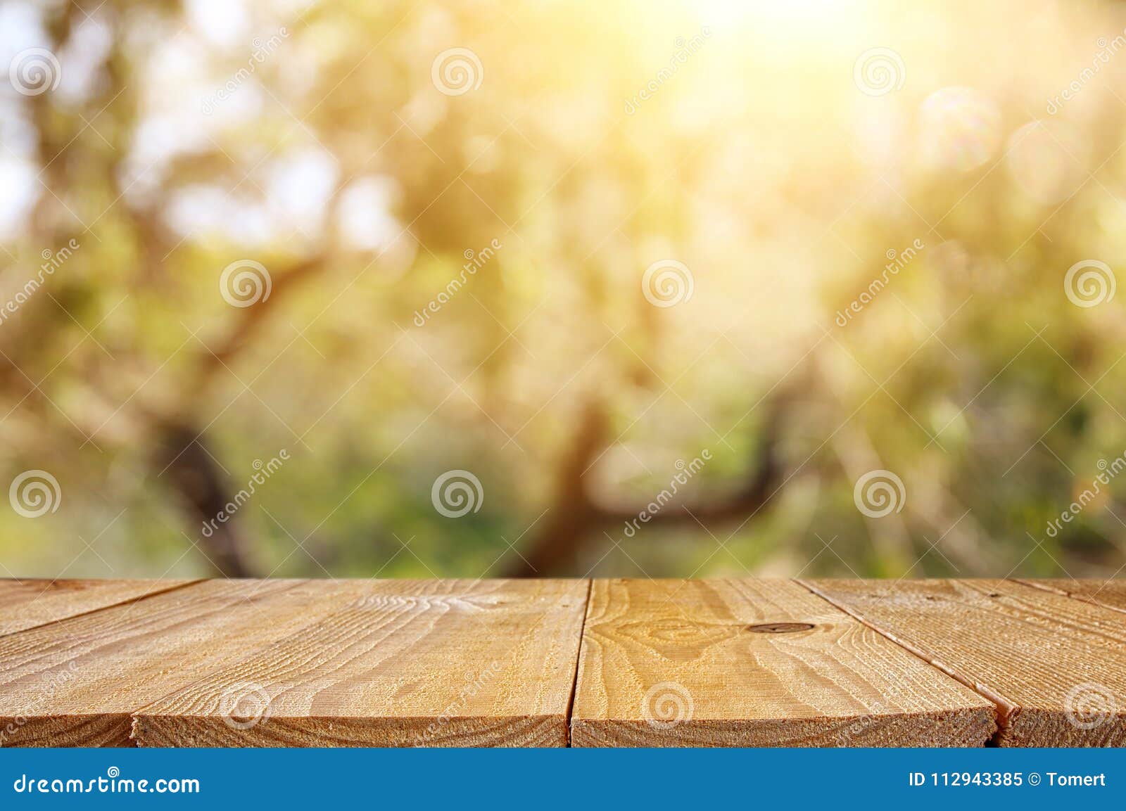 empty rustic table in front of green spring abstract bokeh background. product display and picnic concept.