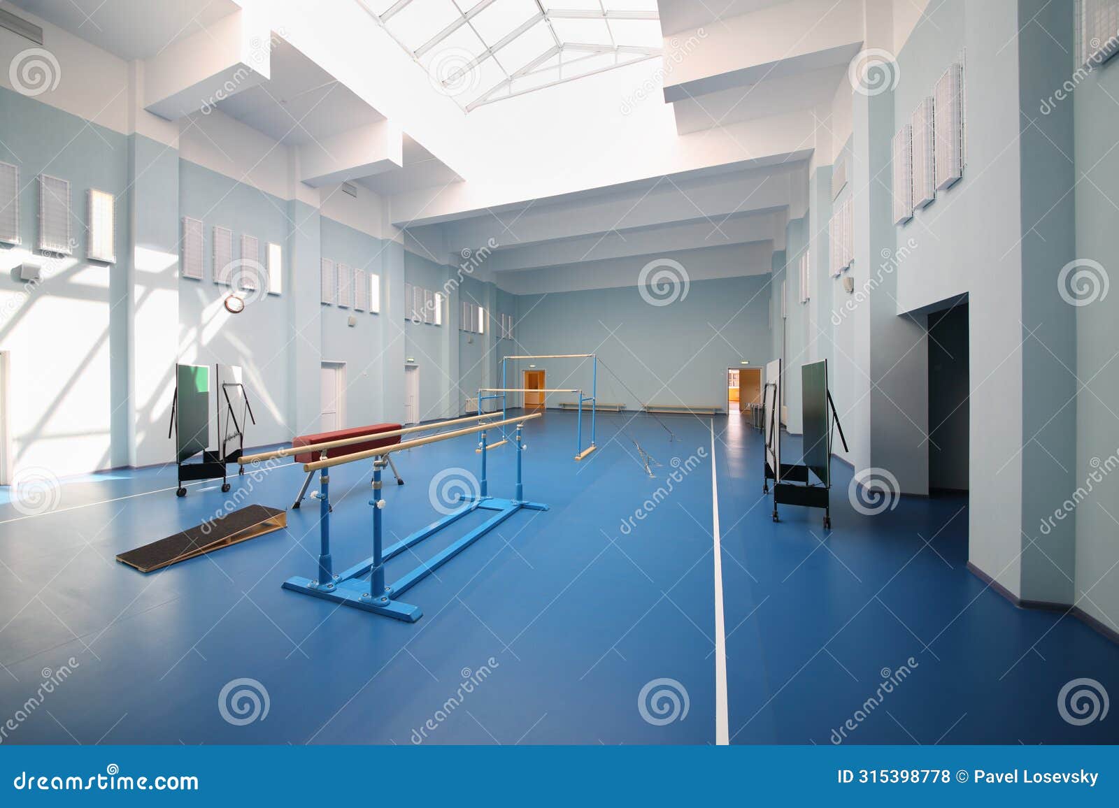 empty school gymnasium with blue floor and