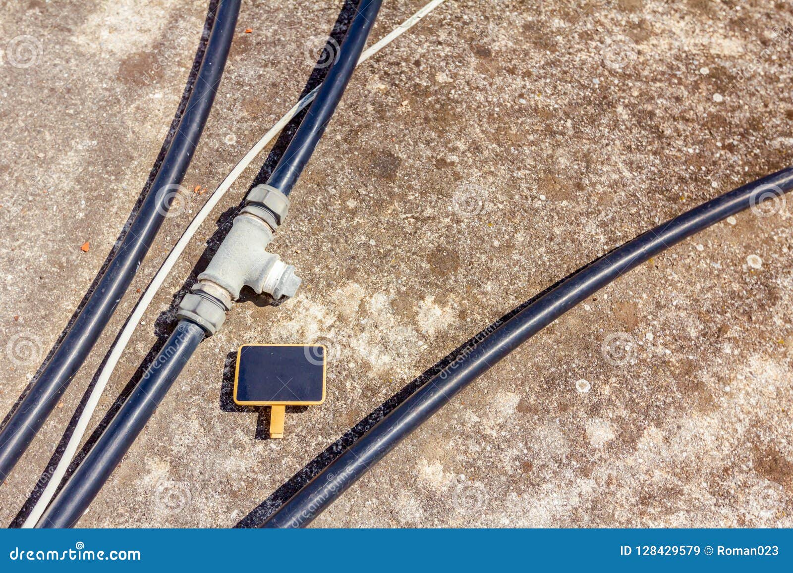 Mini Chalkboard among Plastic Black Water Hoses with Metal Bifurcation Element Stock Image
