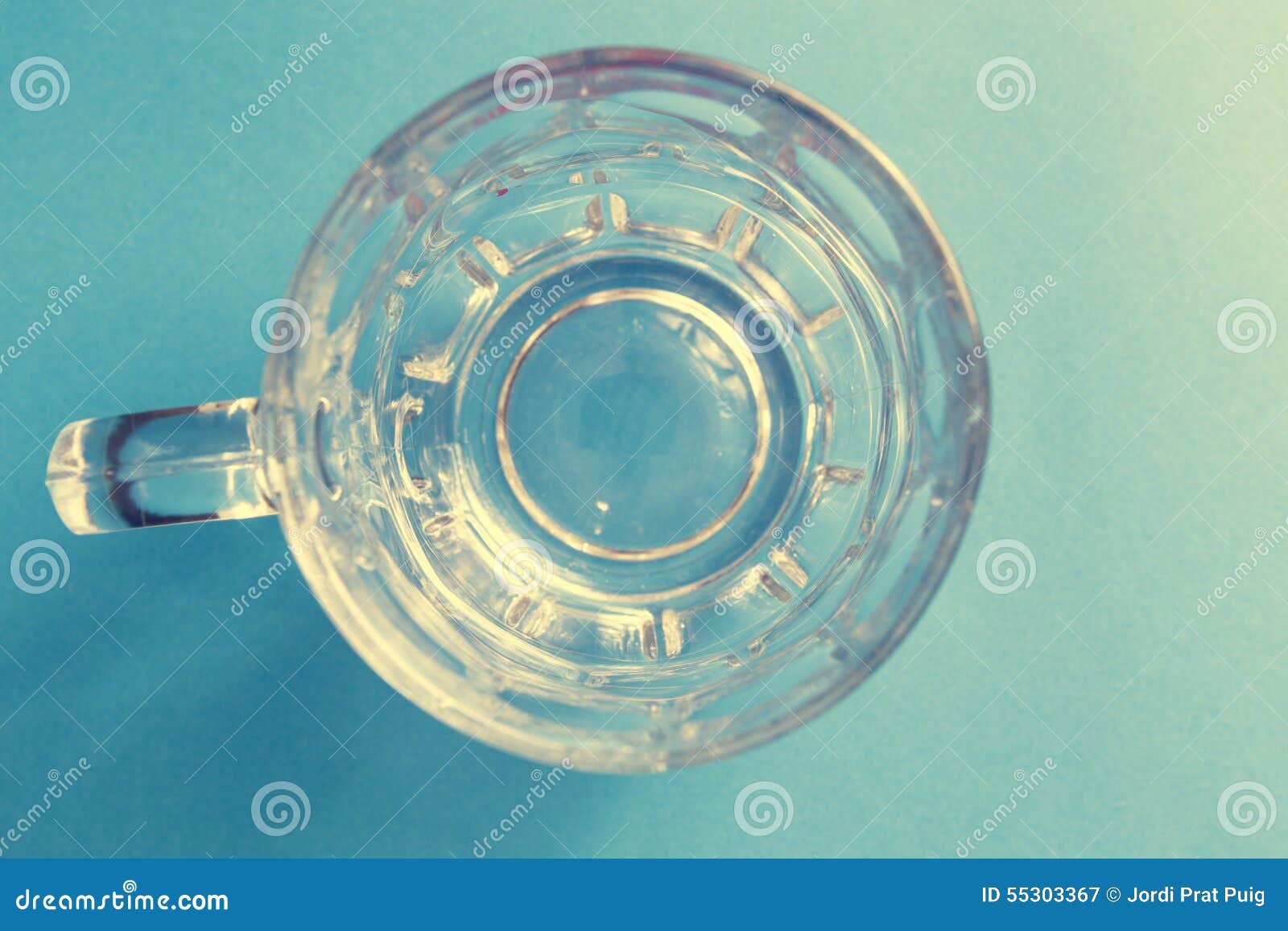 empty and transparent glass beer jar on a blue background