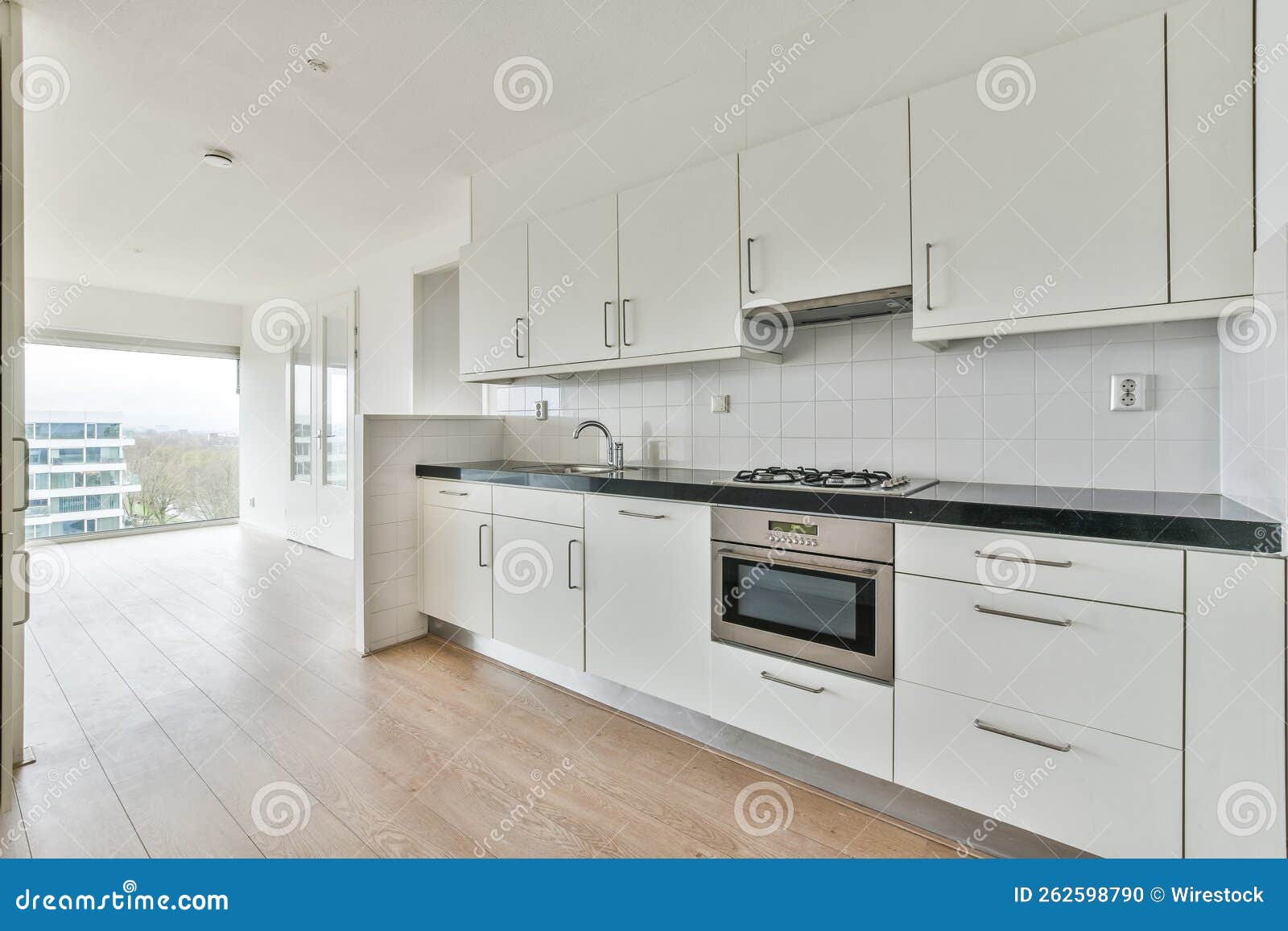 Empty White Kitchen with Laminate Flooring and Closets Stock Photo