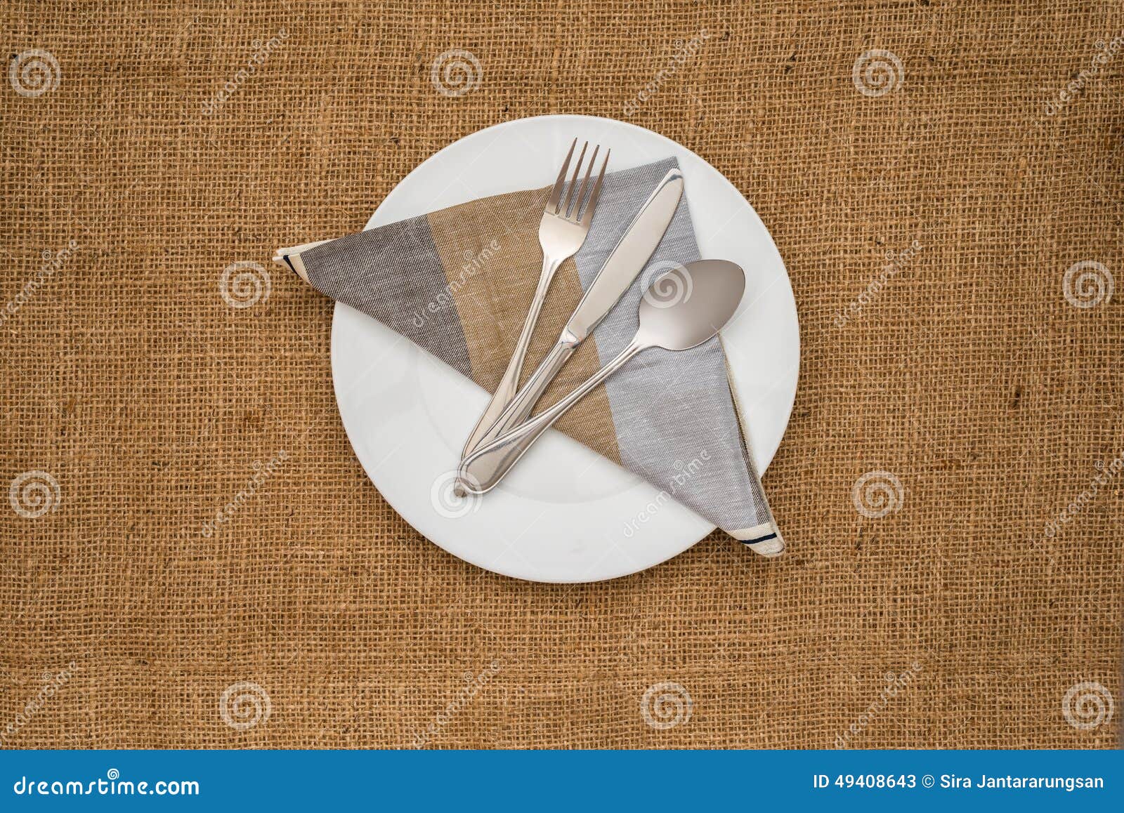 Empty white plate and spoon, fork, knife, napkin. Empty white plate spoon, fork, knife, napkin on sackcloth background