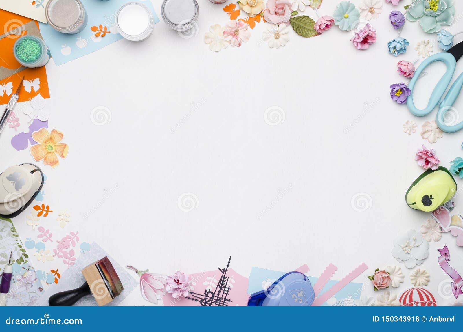empty white space in the center surrounded by paper flowers, multi-colored paper and scrapbooking materials