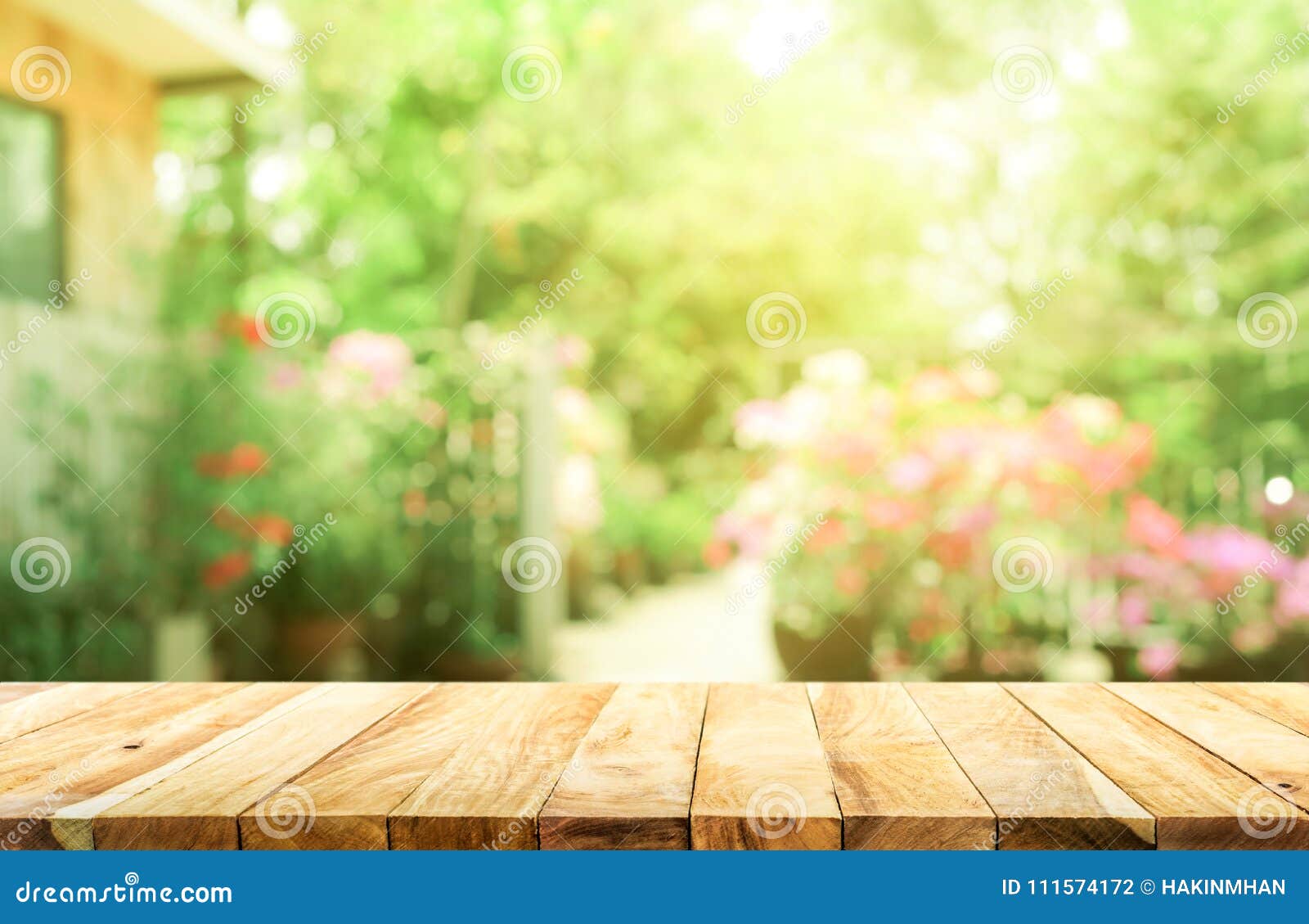 empty wood table top on blur abstract green from garden