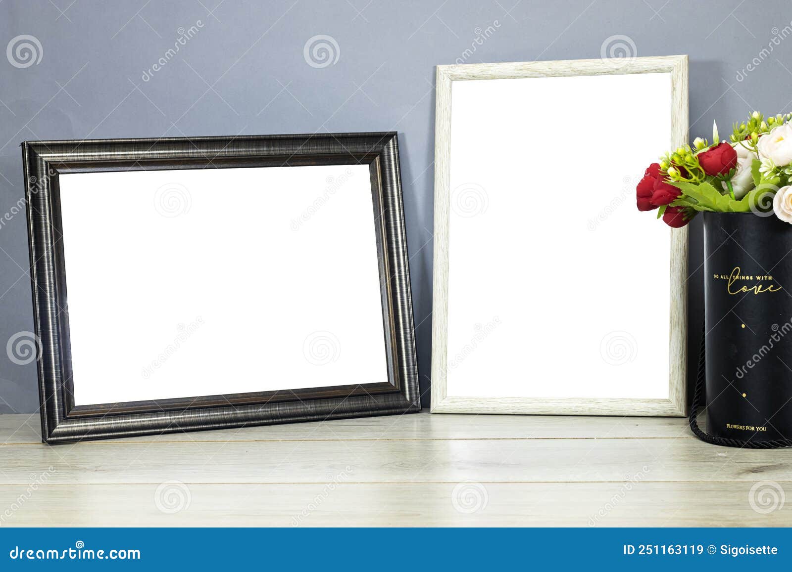 empty wooden ornate picture frames photo with bouquet of flowers on wood table