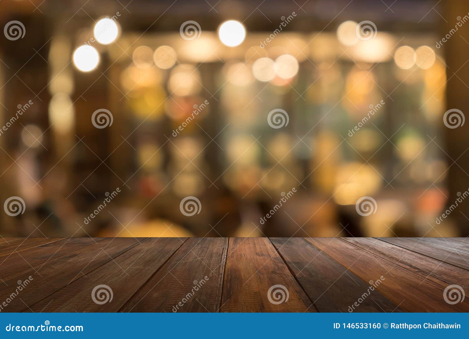 empty wooden table of brown in front warm orange color of bokeh