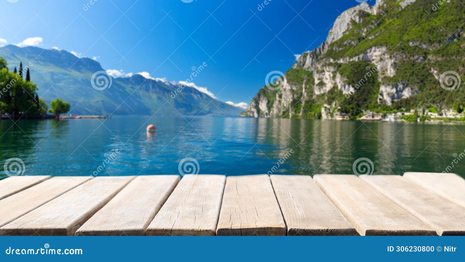 empty wooden table and summer view of lake garda in italy, europe