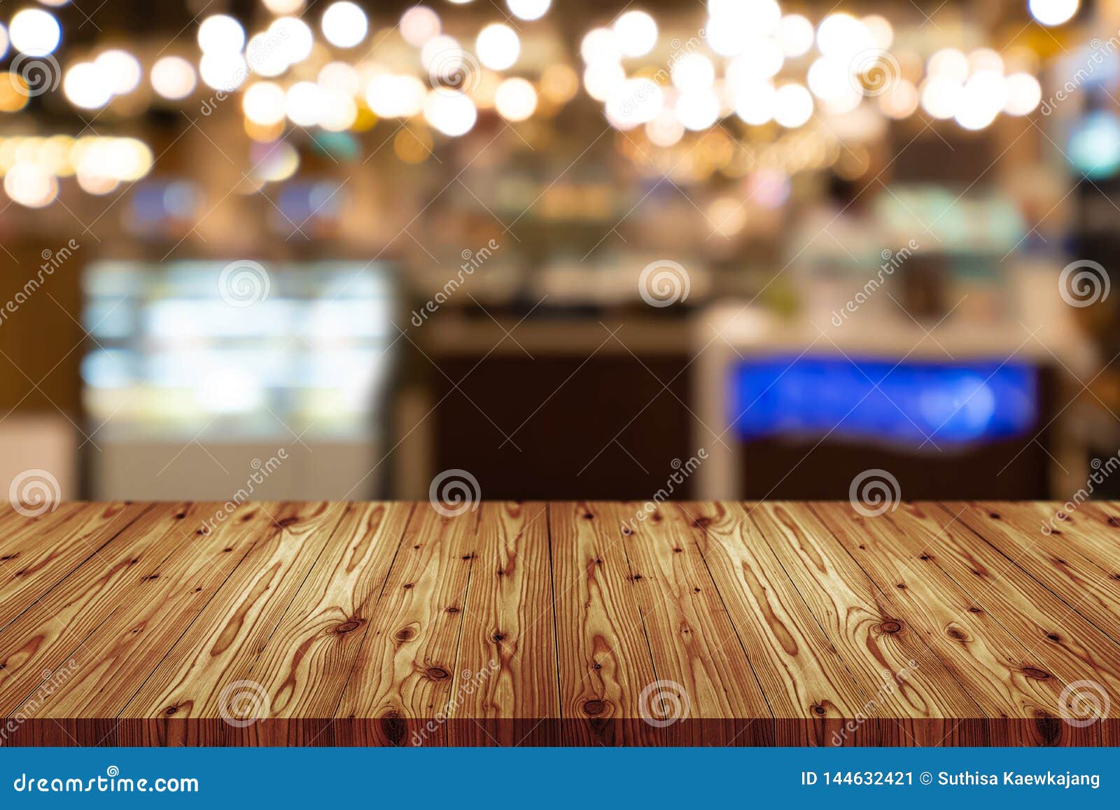 empty wooden table top with blurred of coffee shop, cafe, bar background, abstract background can be used for display or montage