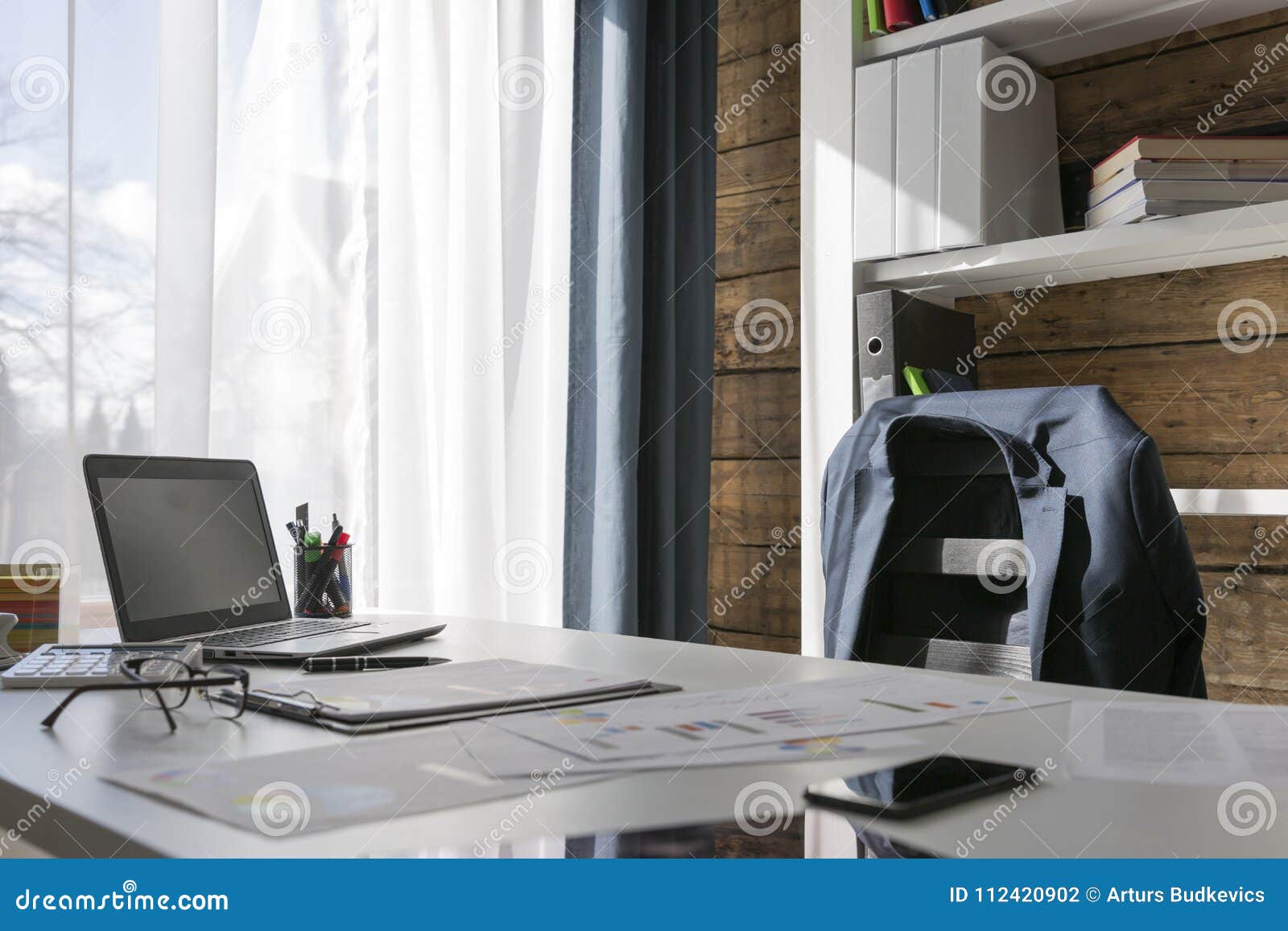 empty workplace with office desk and chair, jacket on the chair,