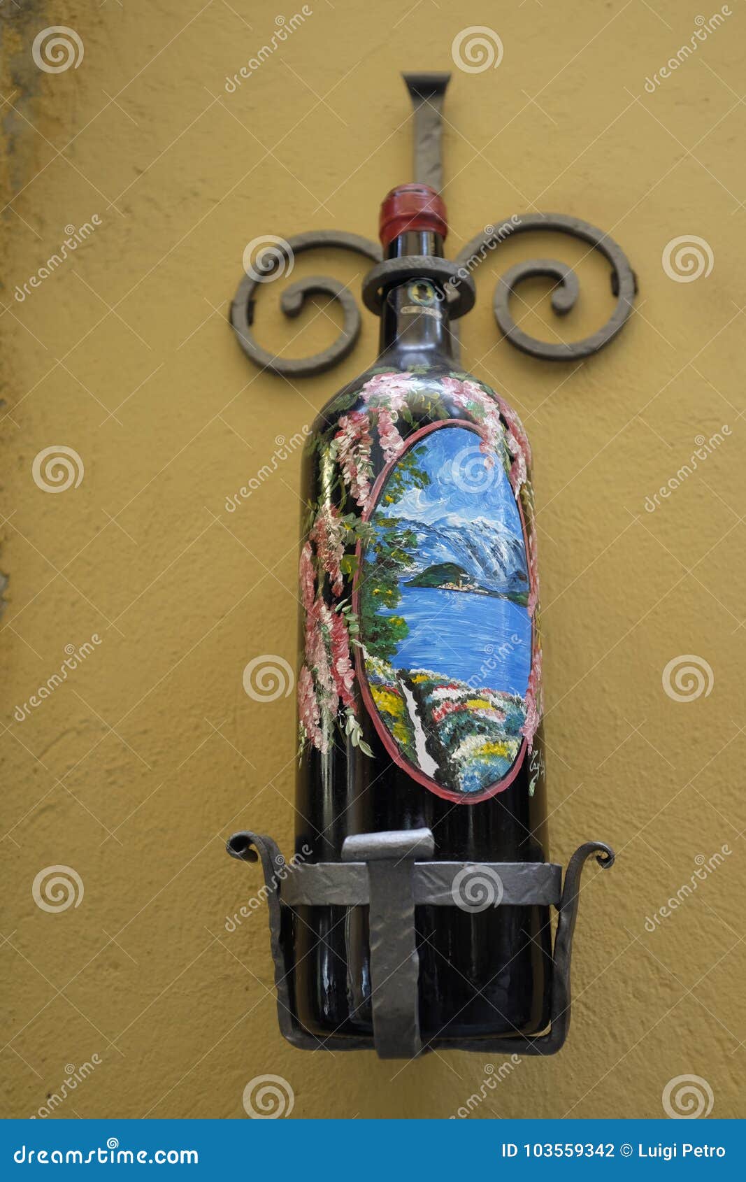 En flaska dekorerade med en sikt av Bellagio på skärm utanför en shopde en shoppa i Bellagio, sjön Como. En vinflaska dekorerar med en siktssjö Como på skärm utanför en souvenir shoppar i Bellagio