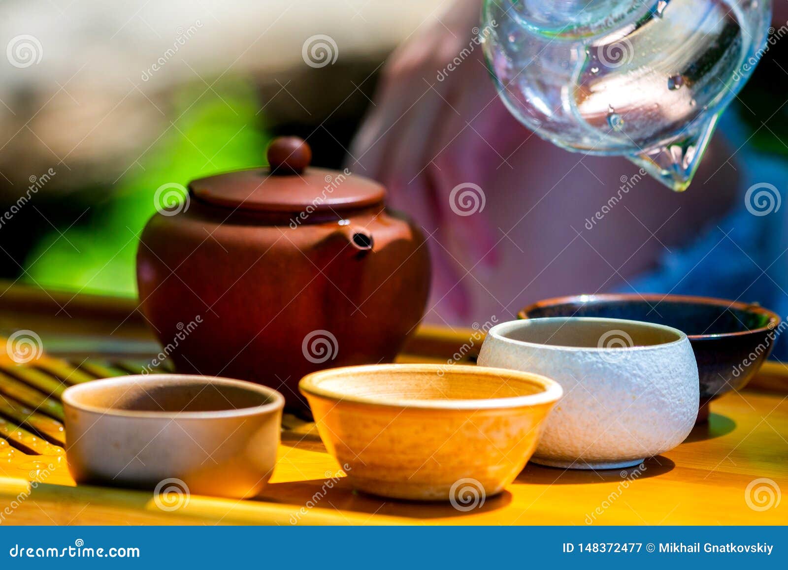 Tetera de cristal con té en una bandeja con el primer de las tazas.