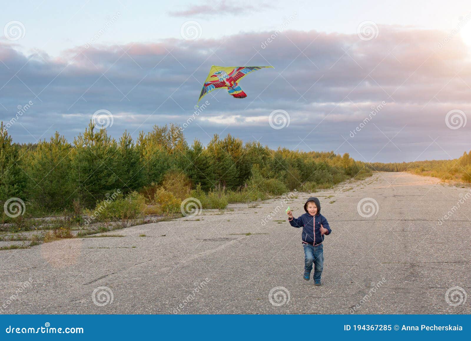 En Pojke Ett Barn Springer Längs Vägen Med En Flygande Drake. Han Lär Sig  Att Flyga En Drake. Barnet Har En Lycklig, Rolig Barndom Fotografering för  Bildbyråer - Bild av relax, prestation: