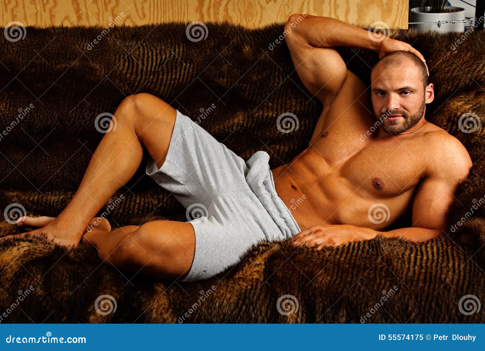 Мужчина сидит раздвинув ноги. Накаченный мужик на диване. Накаченный мужчина лежит. Мускулистый мужчина лежит. Мускулистый парень в кровати.