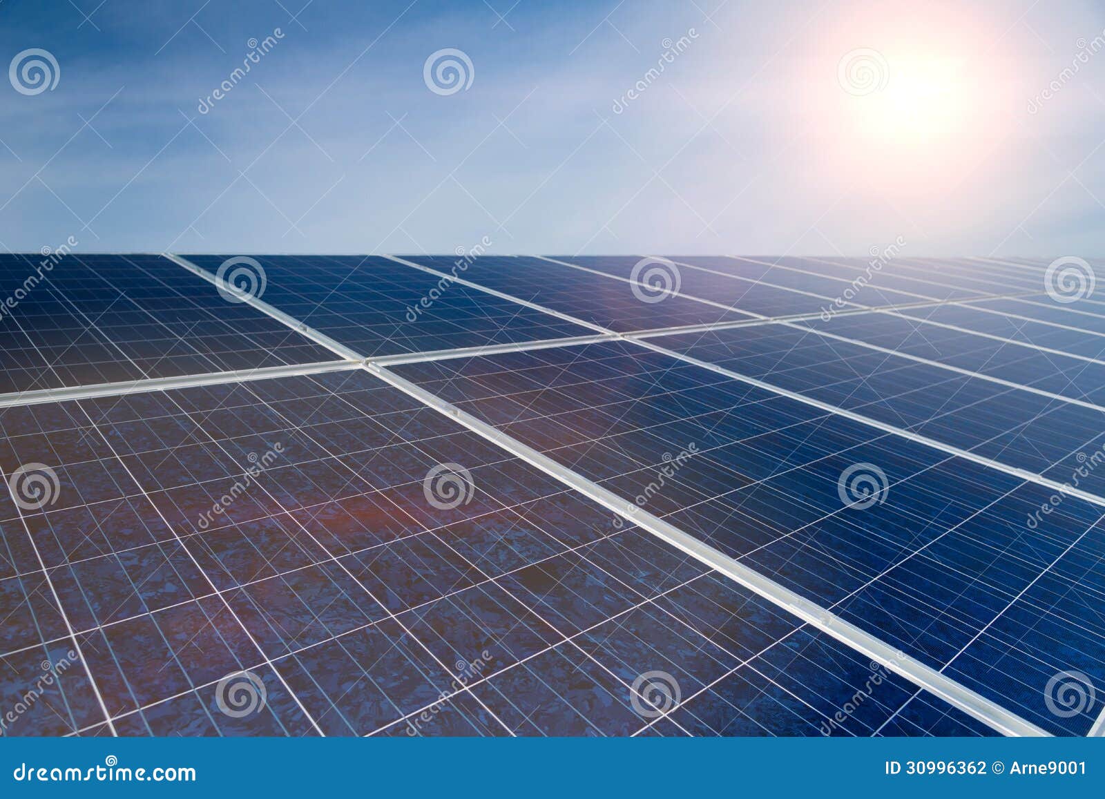 Energia verde - painéis solares com céu azul. Sistema fotovoltaico com os painéis solares para a produção de energia renovável com a energia solar