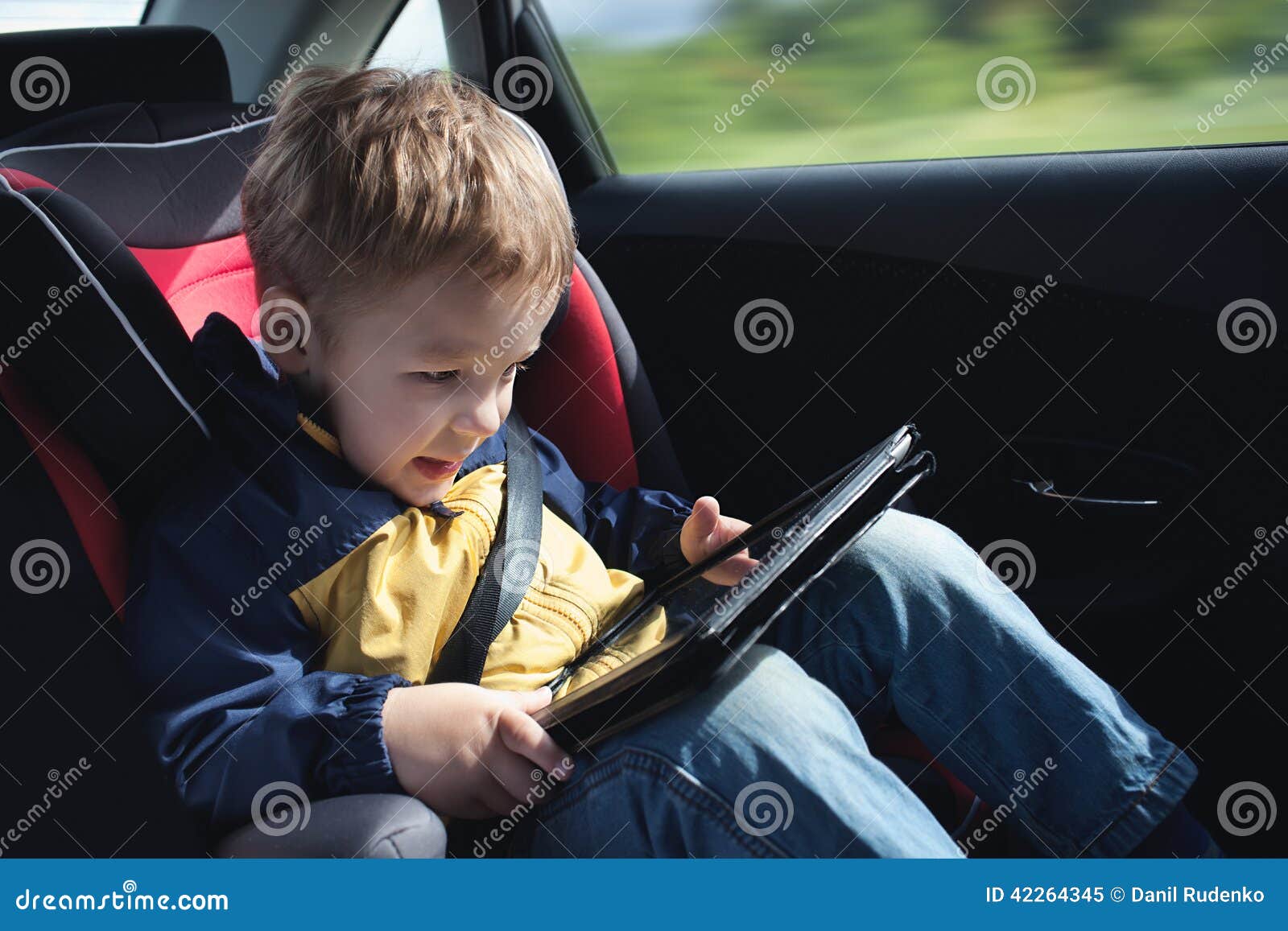Enfant Dans La Voiture Avec La Tablette Image stock - Image du