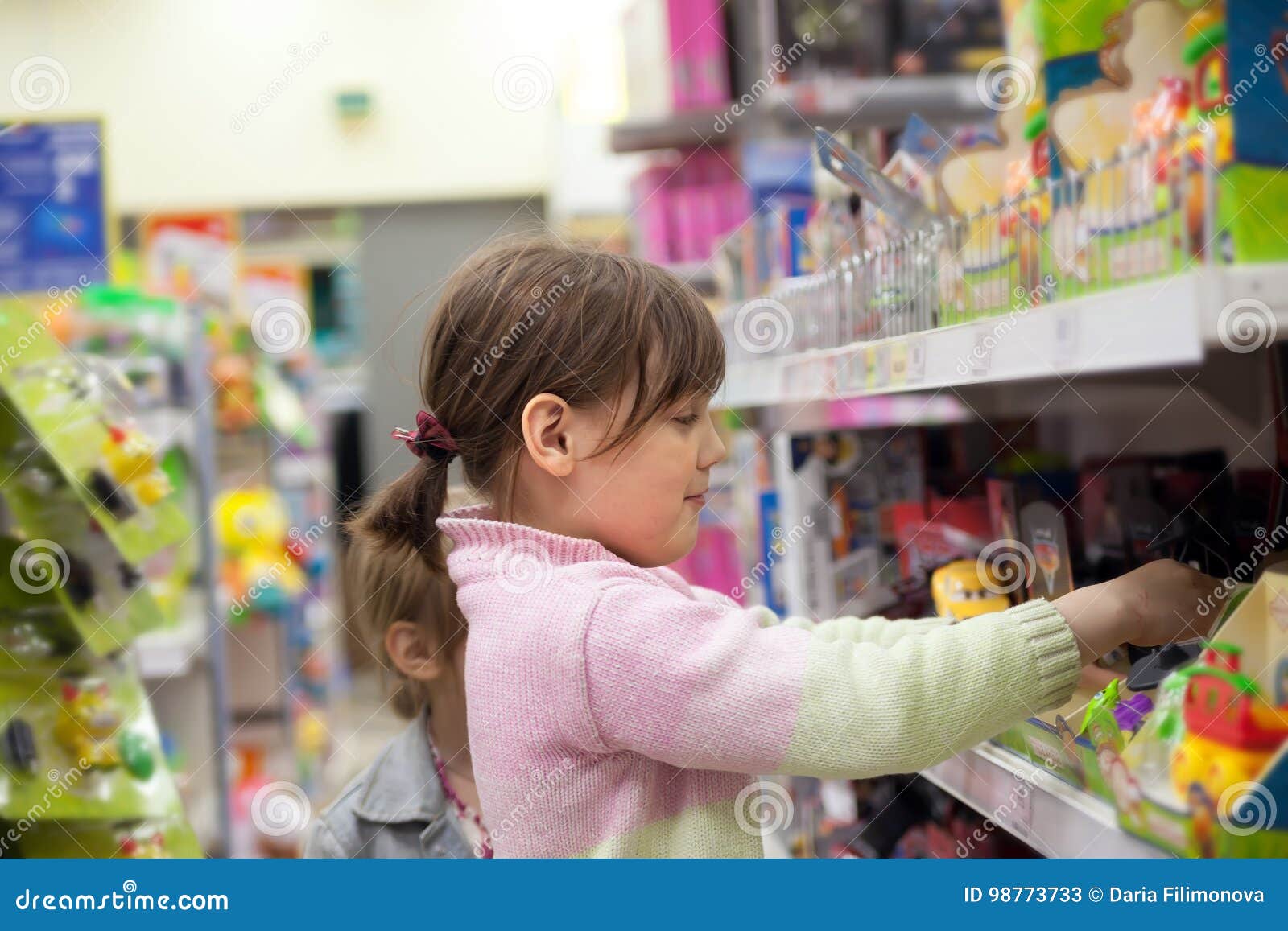 Enfant Dans Le Magasin De Jouet Choisissant L'achat Image stock
