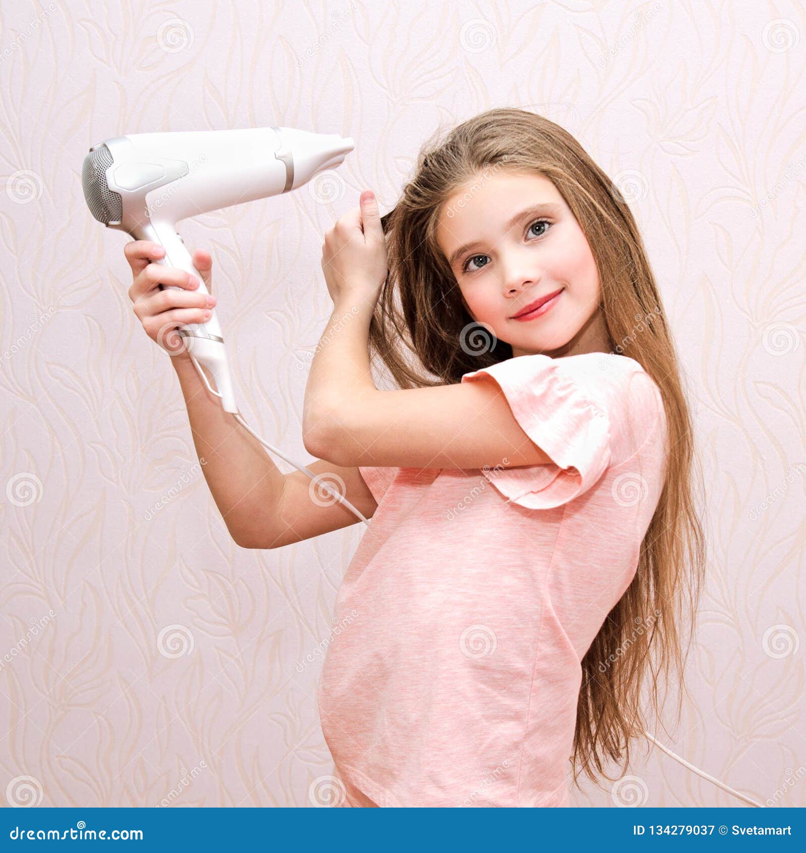 Enfant De Sourire Mignon De Petite Fille Séchant Ses Longs Cheveux Avec Le  Sèche-cheveux Photo stock - Image du rose, attrayant: 134279056