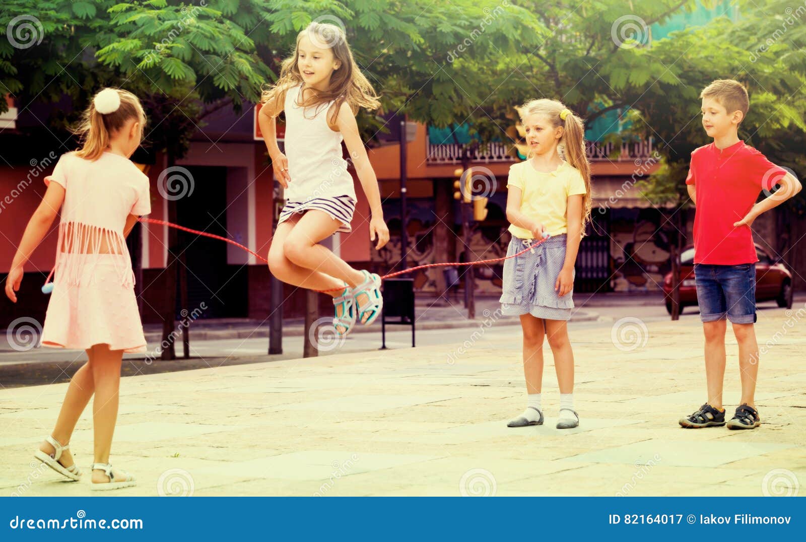 Groupe D'enfants Jouant Avec La Corde À Sauter. Fille Sauter À