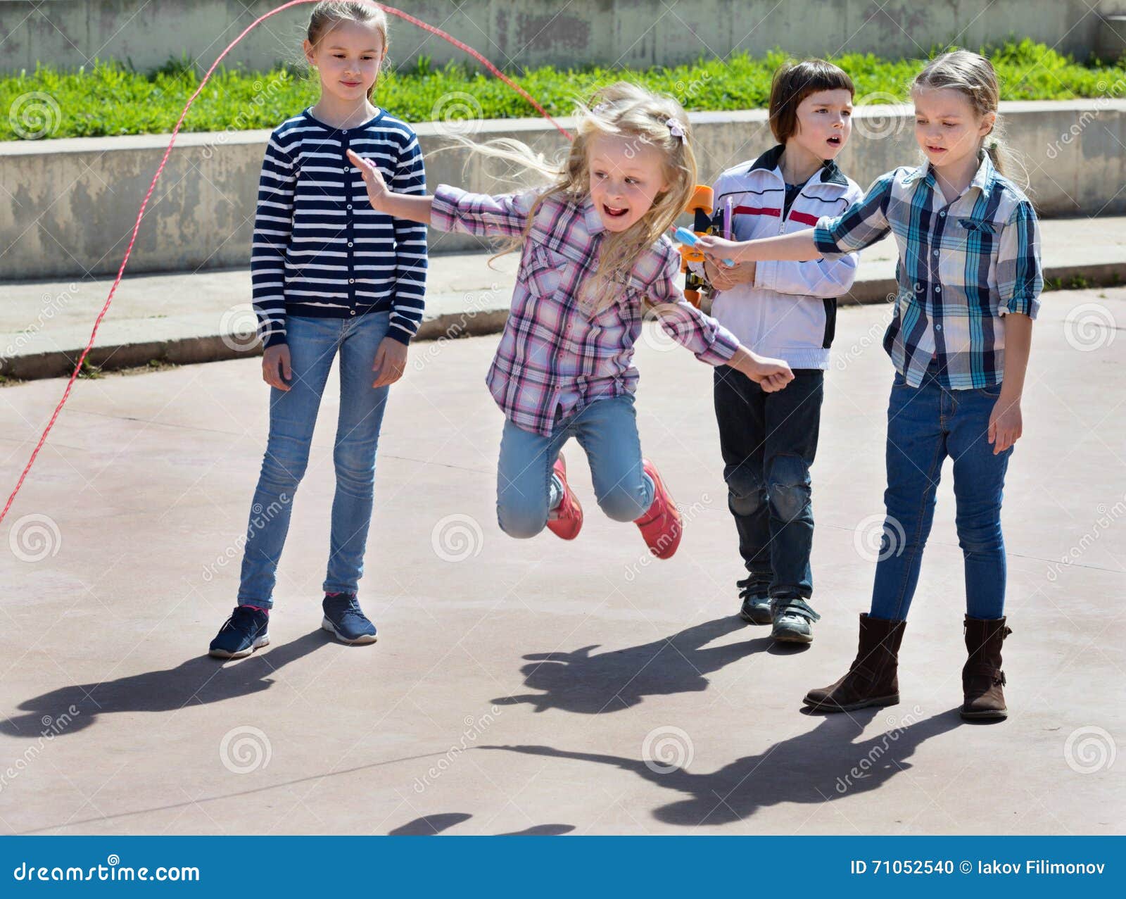 Enfants Jouant Le Jeu Sautant De Corde à Sauter Image stock