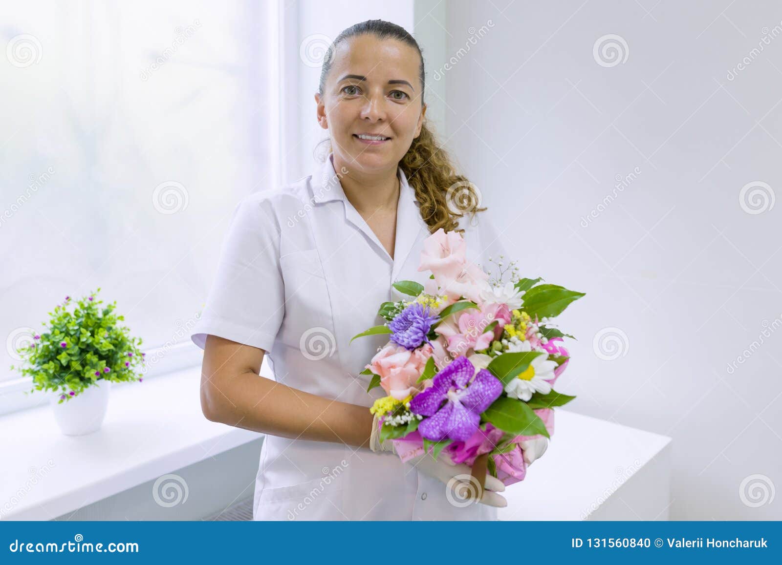 Enfermera De La Mujer Con El Ramo De Flores, Sonriendo Cerca De La Ventana  En El Hospital Día Nacional Del ` S Del Doctor Foto de archivo - Imagen de  medicina, cara: 131560840