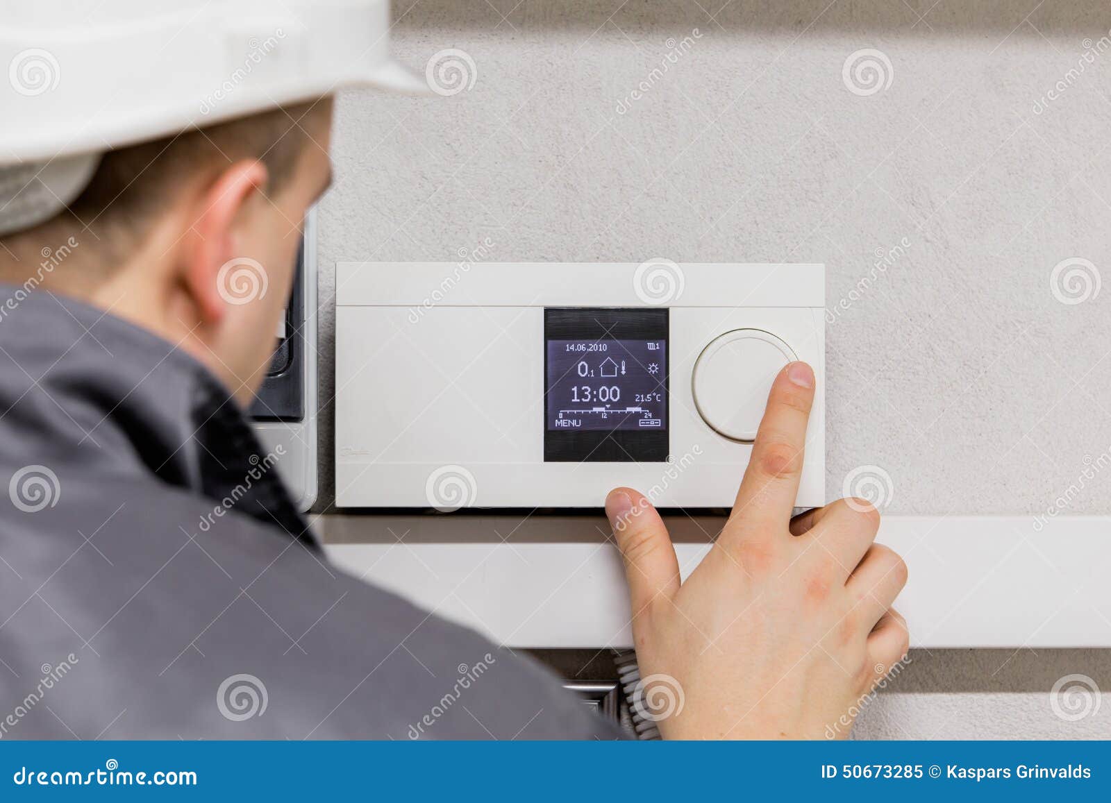 engineer adjusting thermostat for efficient automated heating system