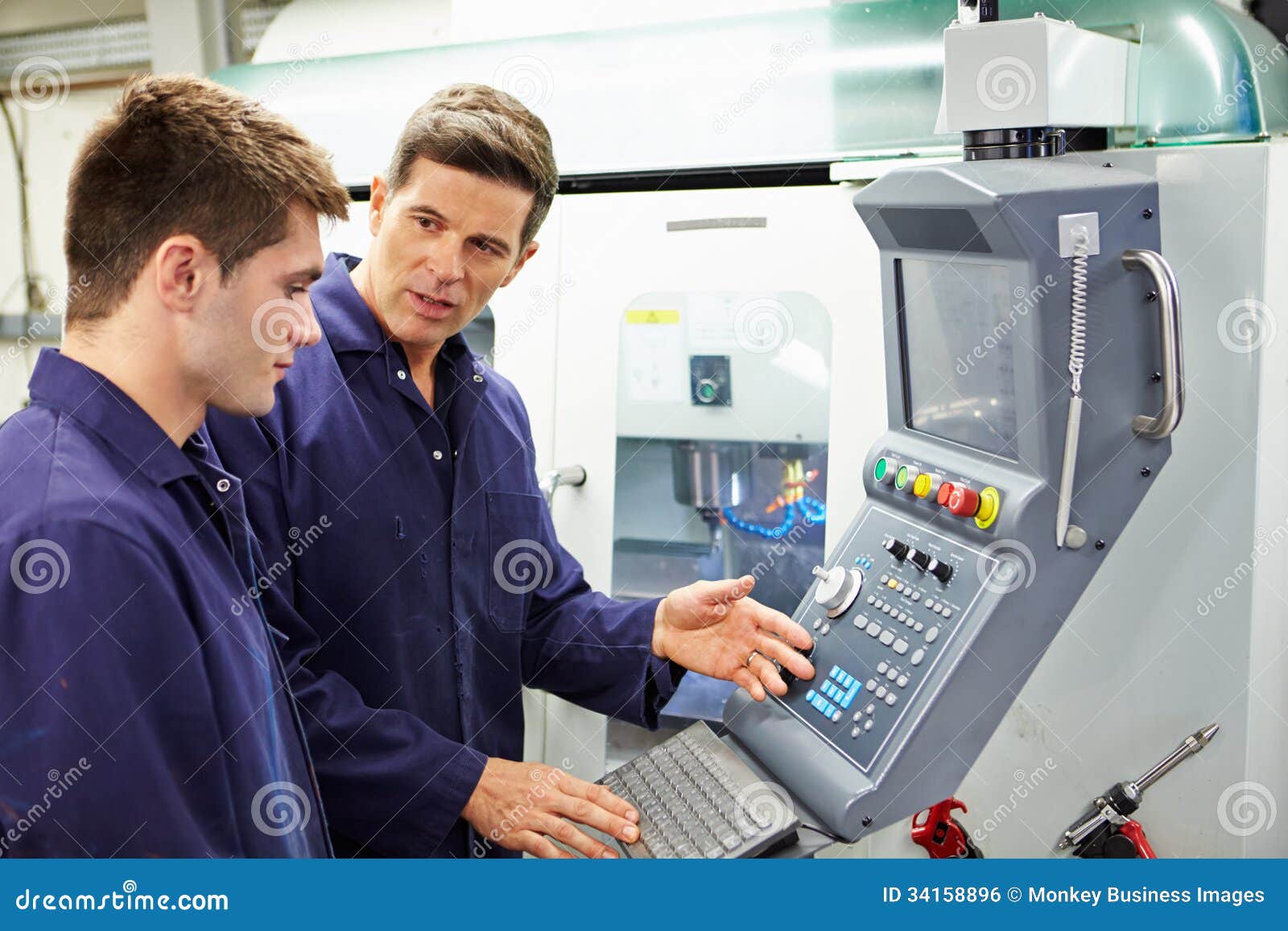 engineer and apprentice using automated milling machine