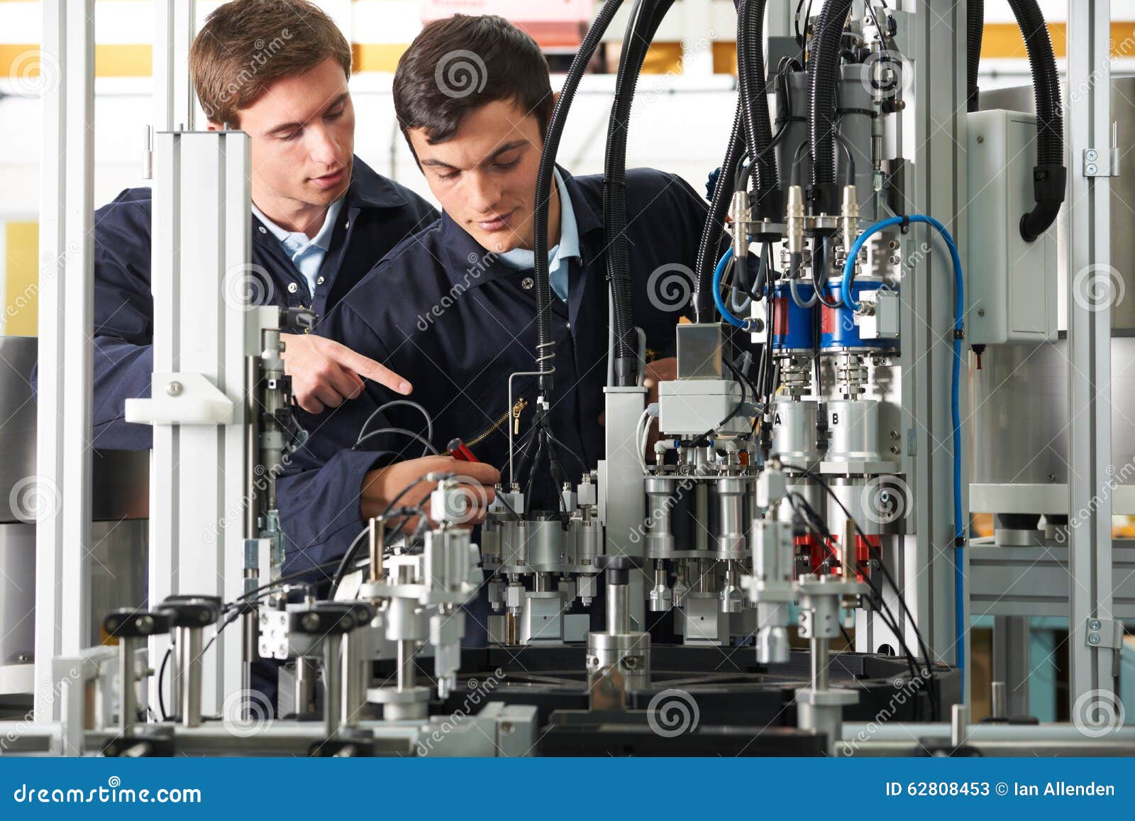 Engineer and Apprentice Working on Equipment in Factory Stock Image