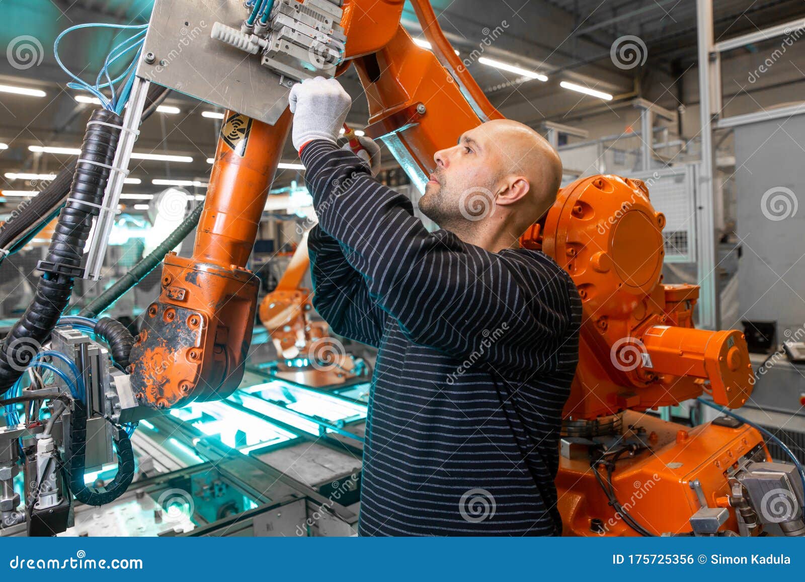Engineer Doing Maintenance on a Automatic Robot Arms in Automotive