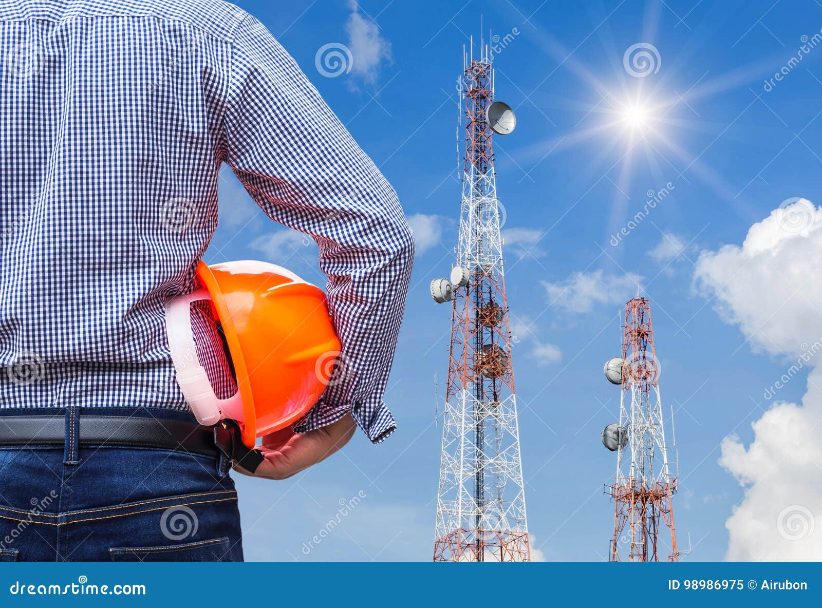 engineer holding safety helmet with telecommunication tower pillars