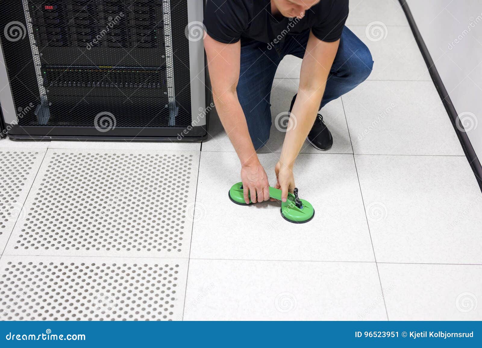 Engineer Lifting Floor Tile Using Vacuum Suction Cups In Datacen