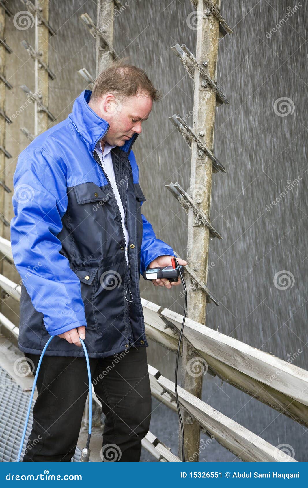 Engineer running tests. Engineer measuring the hydrostatic level of a cooling tower.