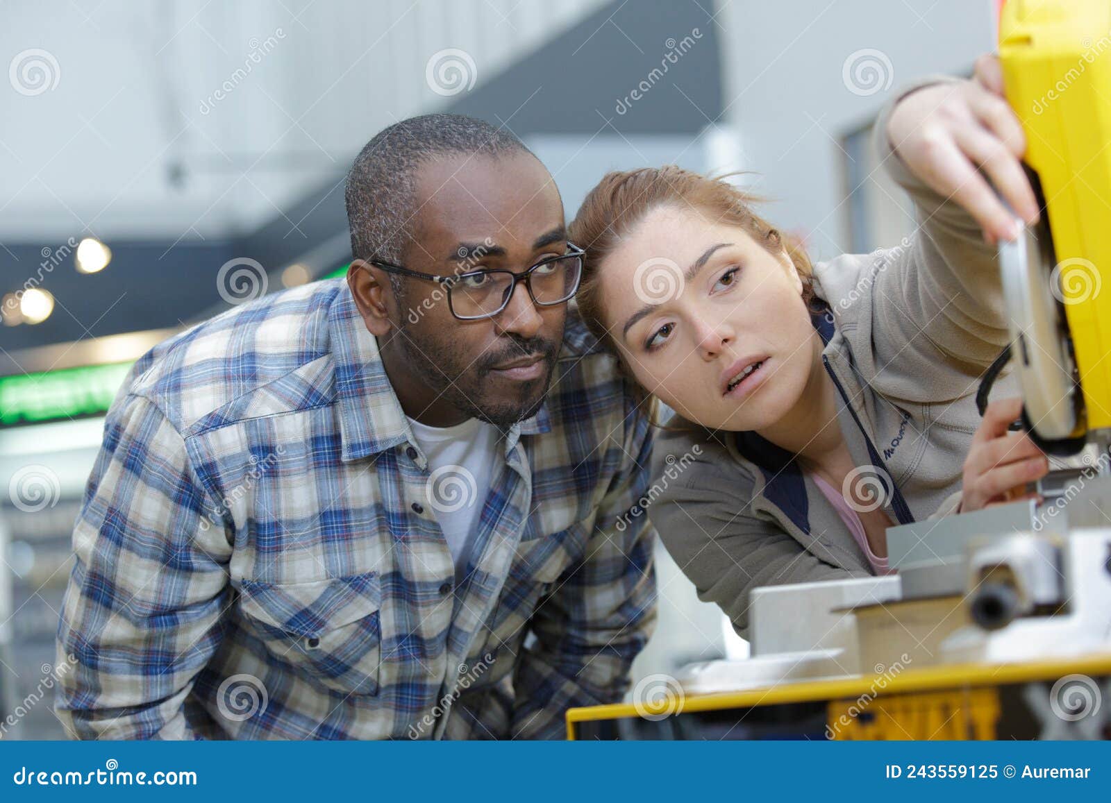 engineer showing apprentice how to use cnc tool making machine