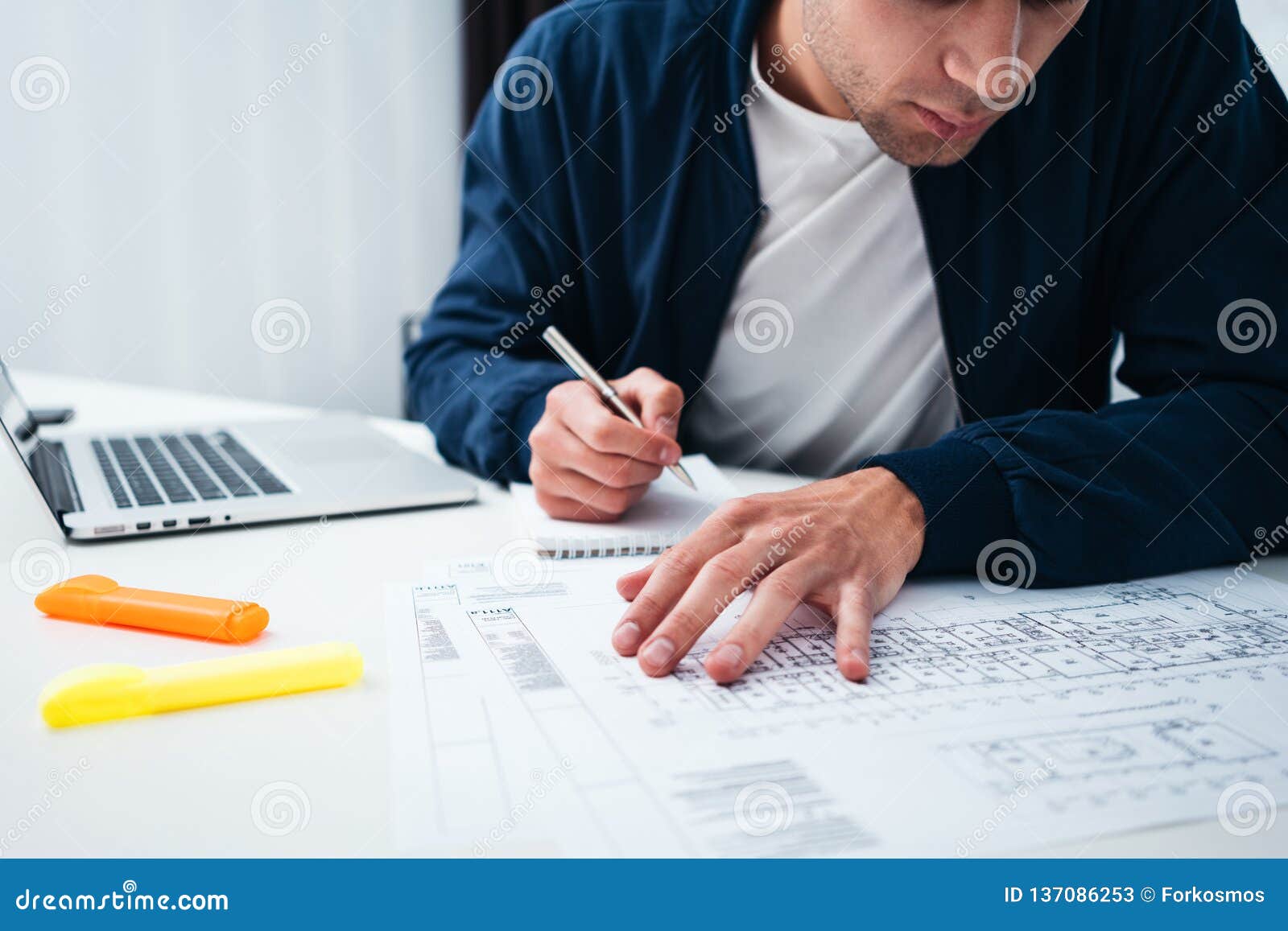 engineer sitting at table and work with buliding drawing