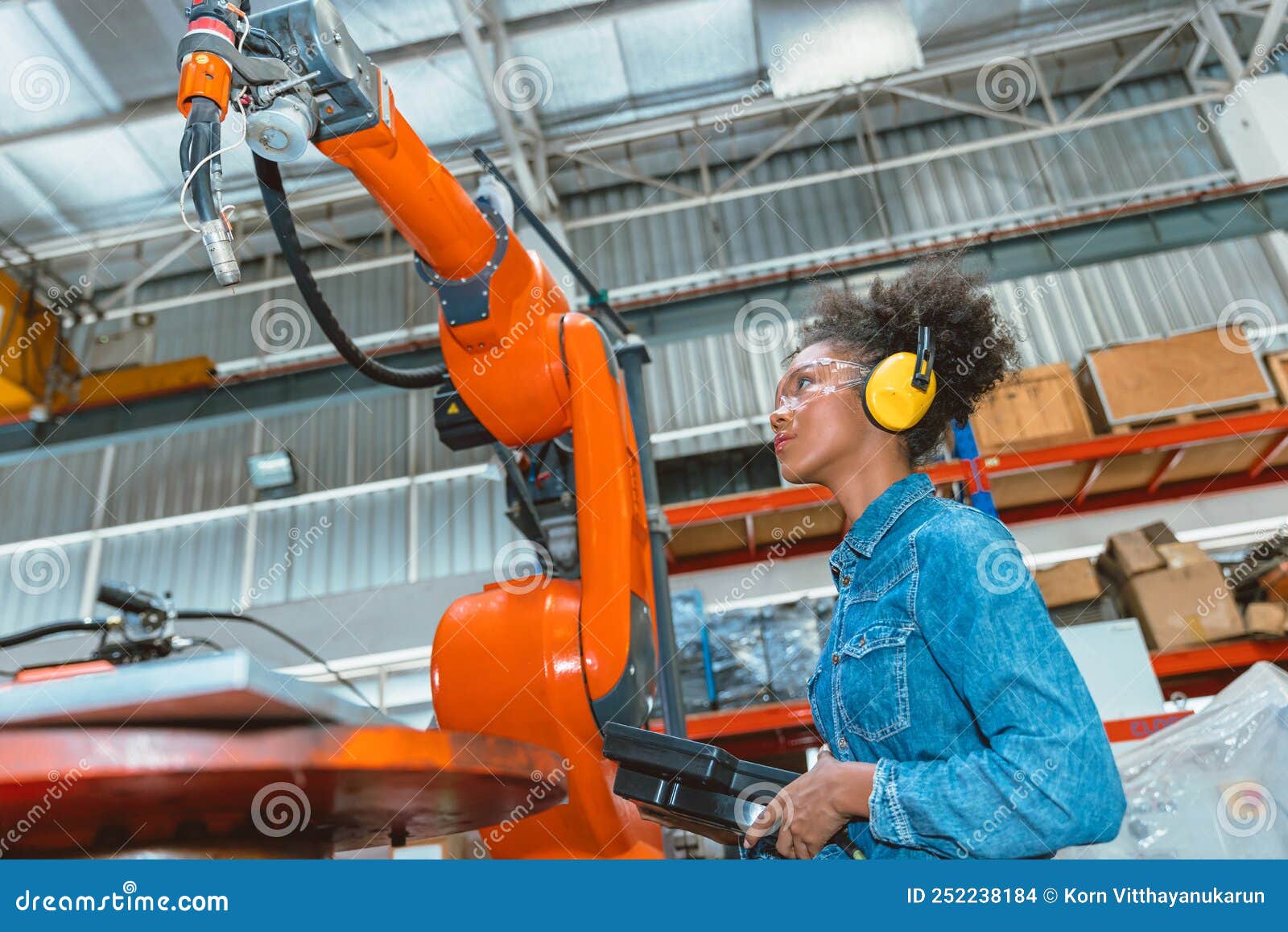 engineer smart woman worker working programing robotic welding machine. black teen girl work in advance modern factory