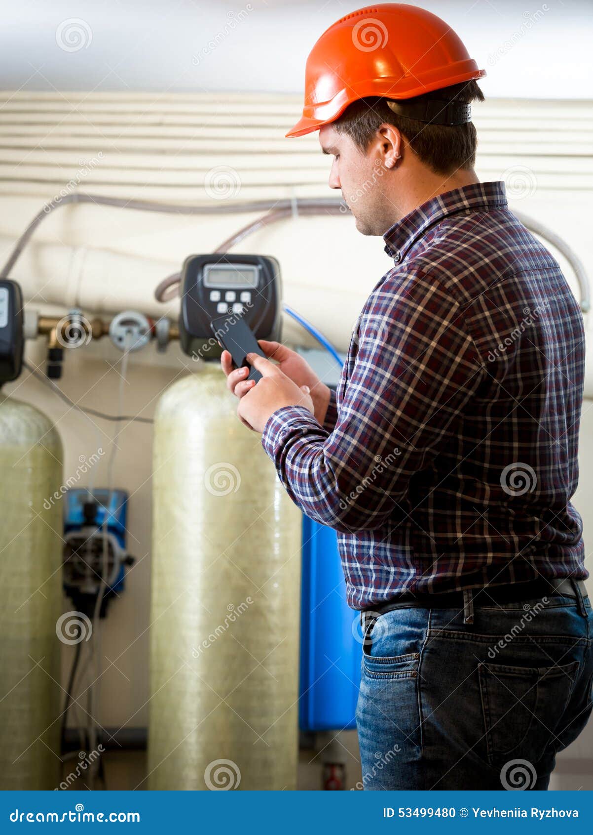 Engineer Taking Meter Readings from Industrial Pumps at Factory Stock