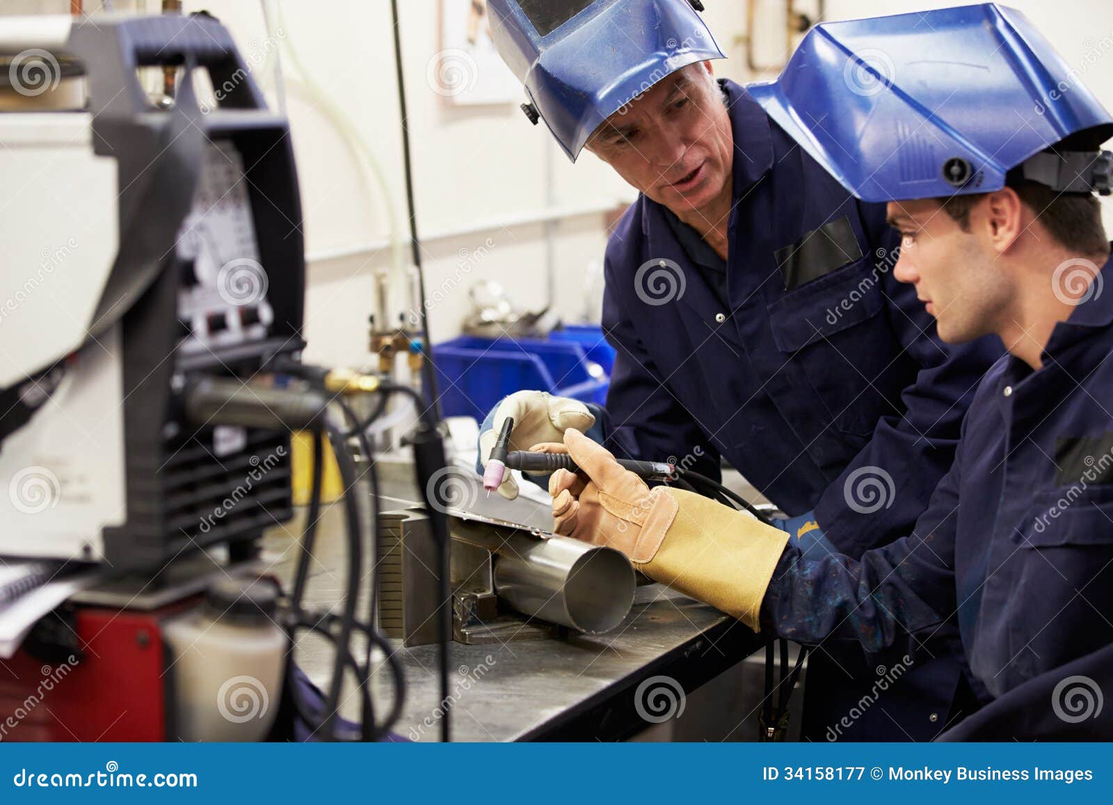 engineer teaching apprentice to use tig welding machine