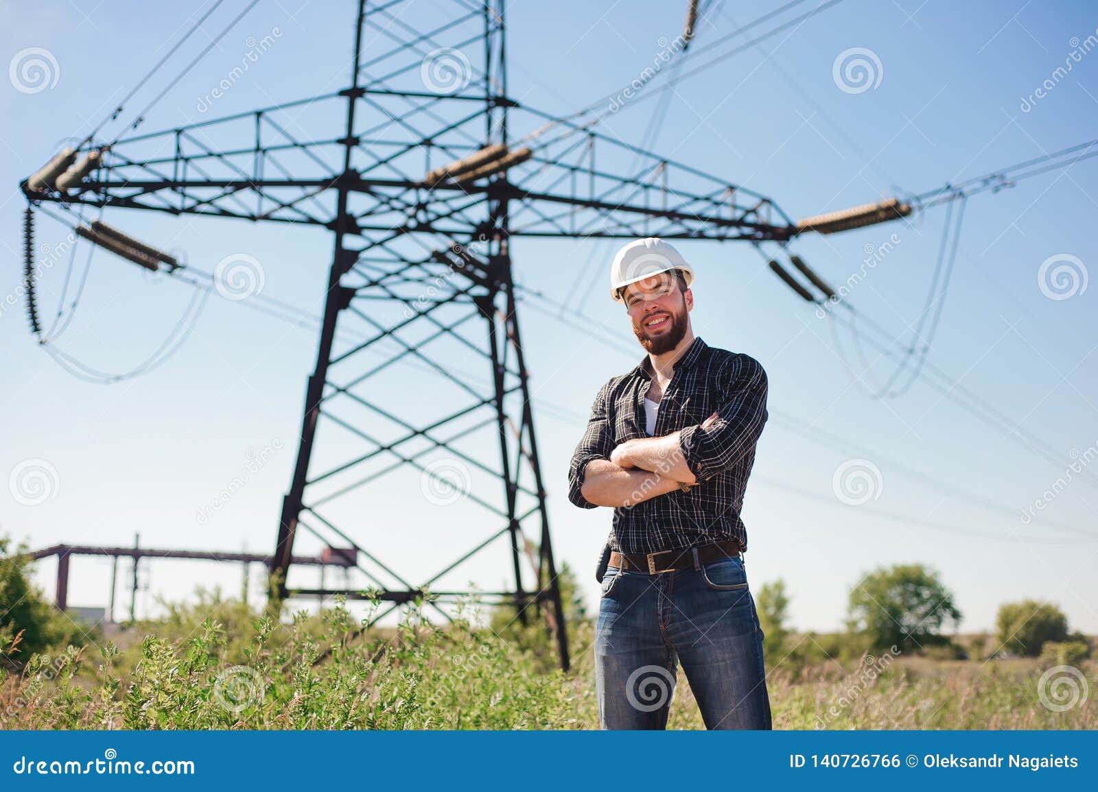 Engineer with White Hard Hat Under the Power Lines. Engineer Work at an