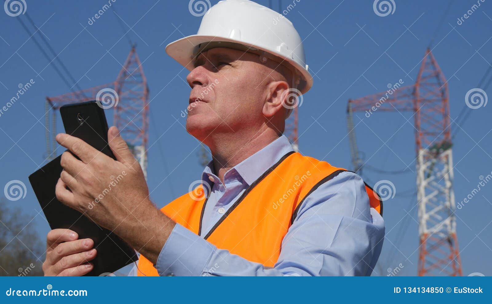 Engineer Work in Energy Industry Doing Maintenance Job with Cell Phone in Hand Stock Photo