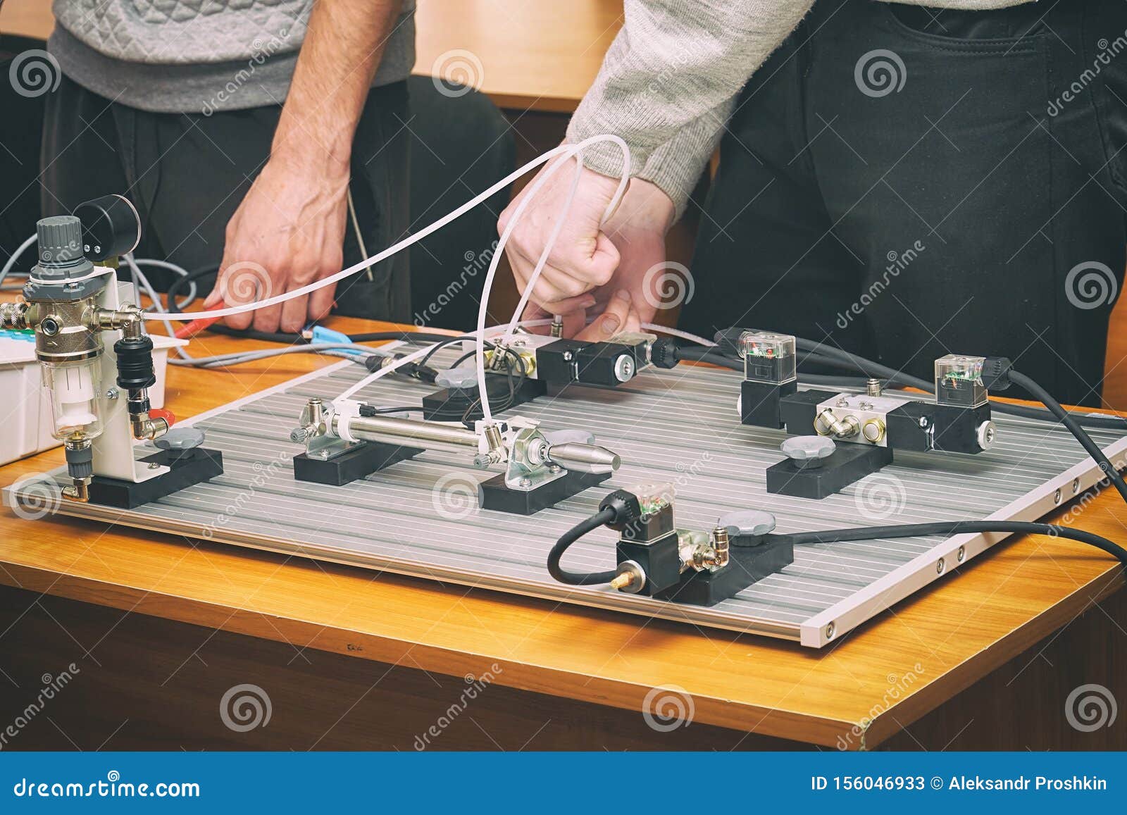 engineers connect wires control panel with small test bench for experiments