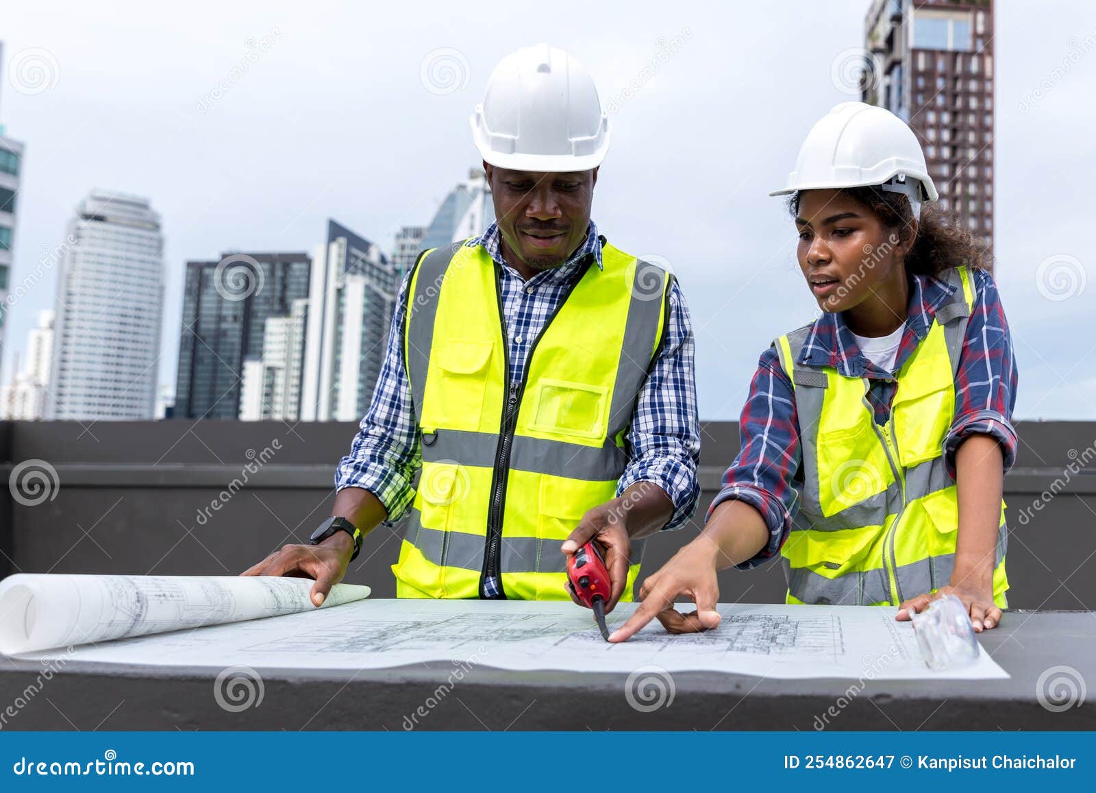 Engineers with Draft Plan of Building on Constructing Site. Engineer