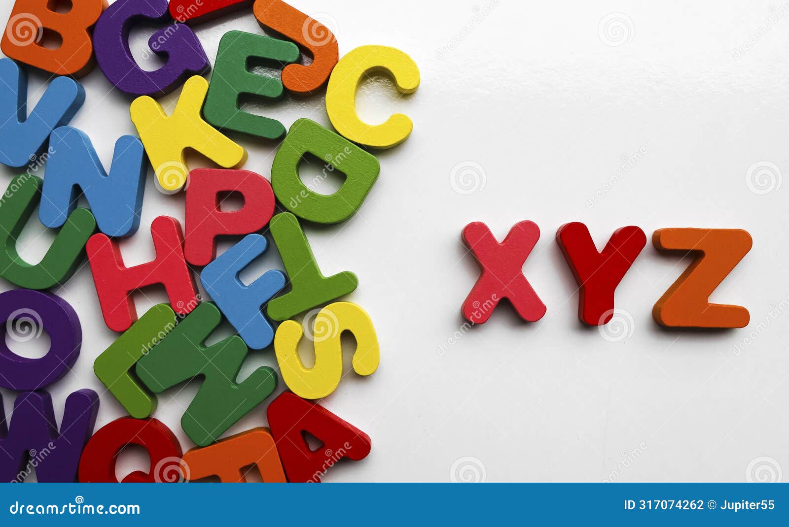 english alphabet on a white background. alphabets on a wooden surface. xyz - letters. scattered mixed colorful wooden letters of